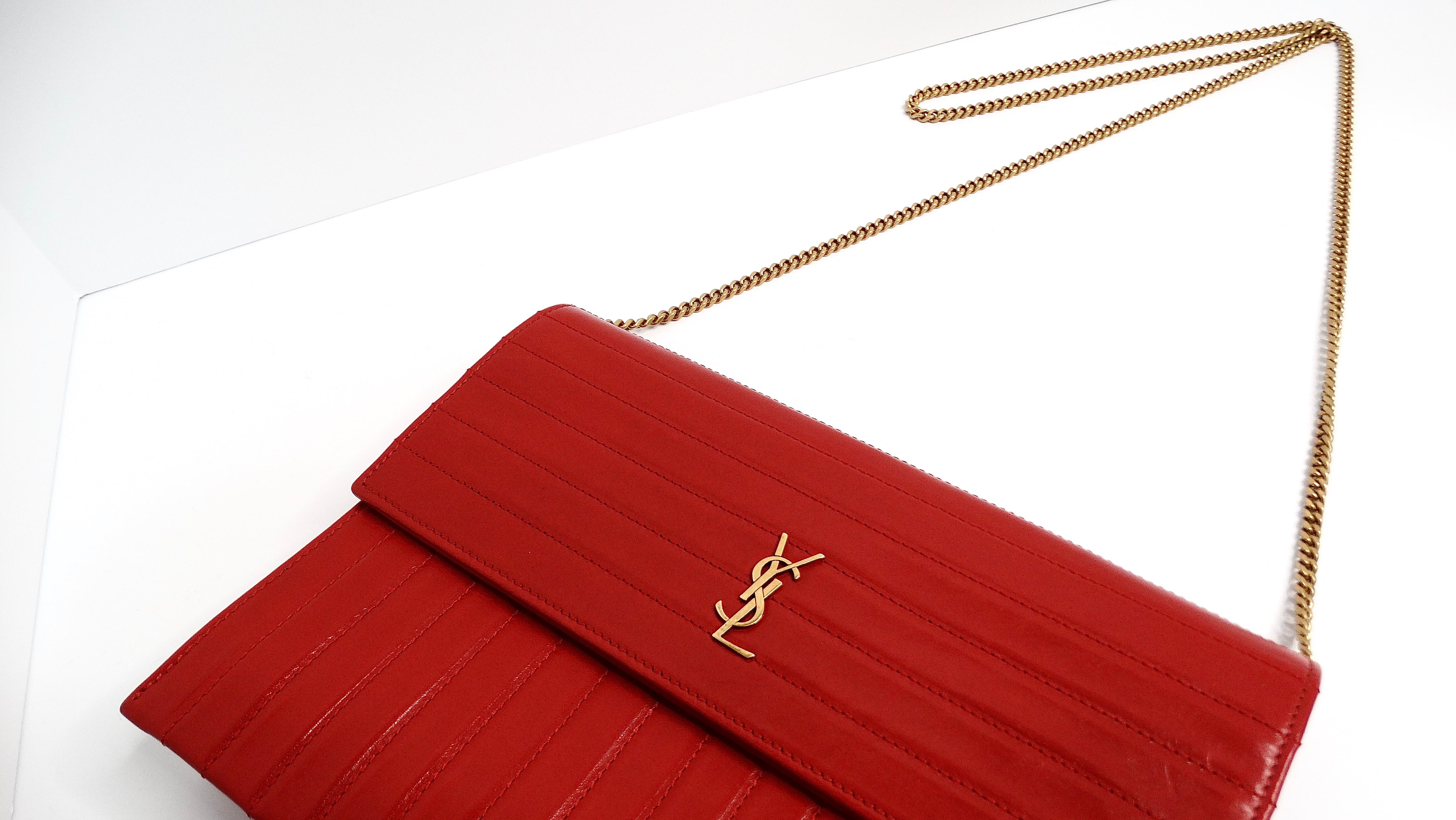 The Saint Laurent Lipstick Red and Gold-Tone Chain Crossbody Handbag is a striking and elegant piece that exudes sophistication. Made from luxurious leather, the bag features the iconic 