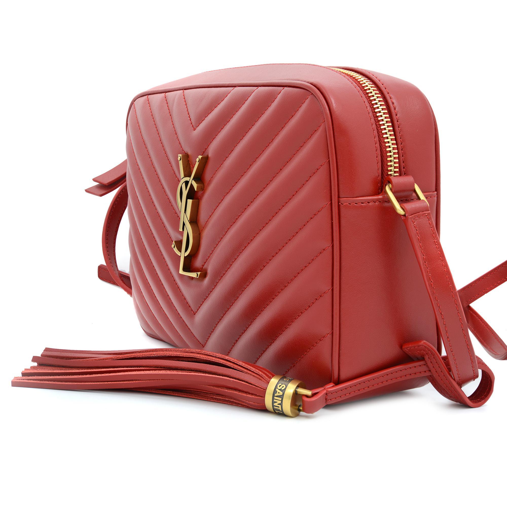 Lou Matelassé Red Leather Camera Bag by Yves Saint Laurent. Features quilted leather with removable tassel detail and iconic YSL logo initials interlaced in metal at the center. Comes with top zip closure and an adjustable shoulder strap with 23
