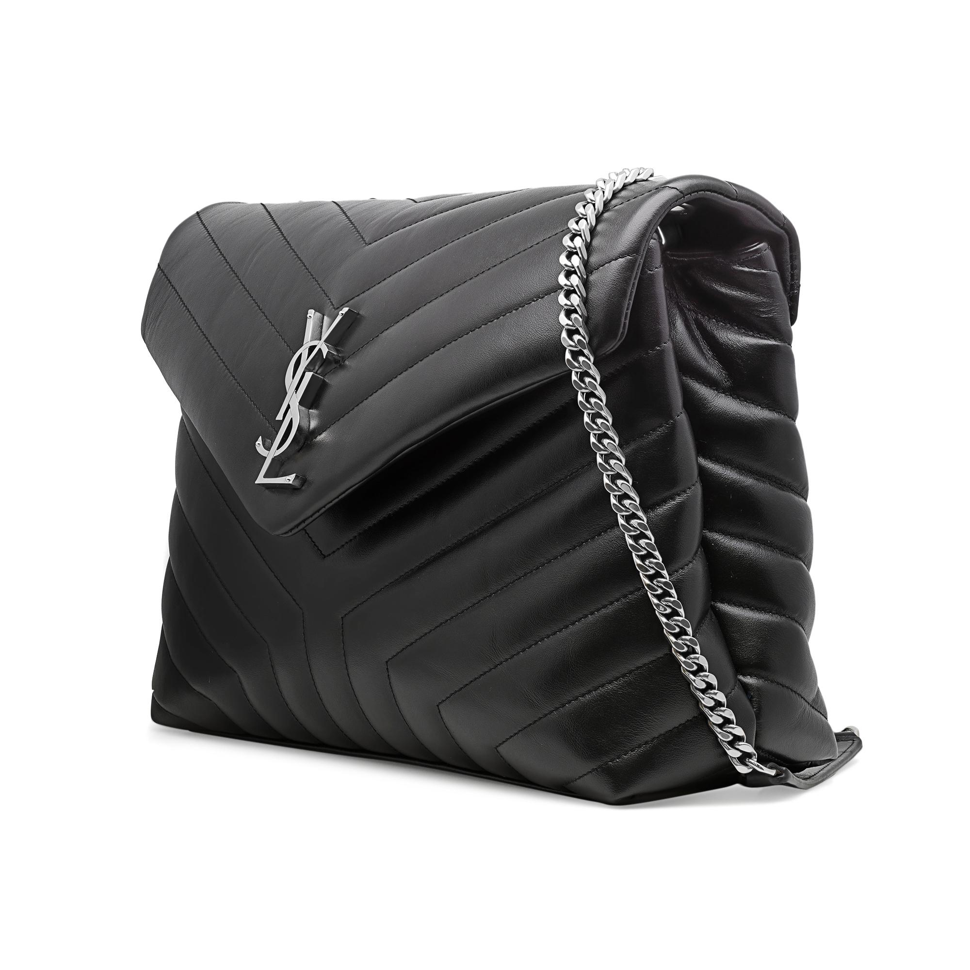 Saint Laurent luxe black quilted leather shoulder bag with adjustable chain straps. Features front flap with interlaced metal YSL initials. Silver tone hardware, quilted finish leather. Magnetic snap closure. Two main interior compartments separated
