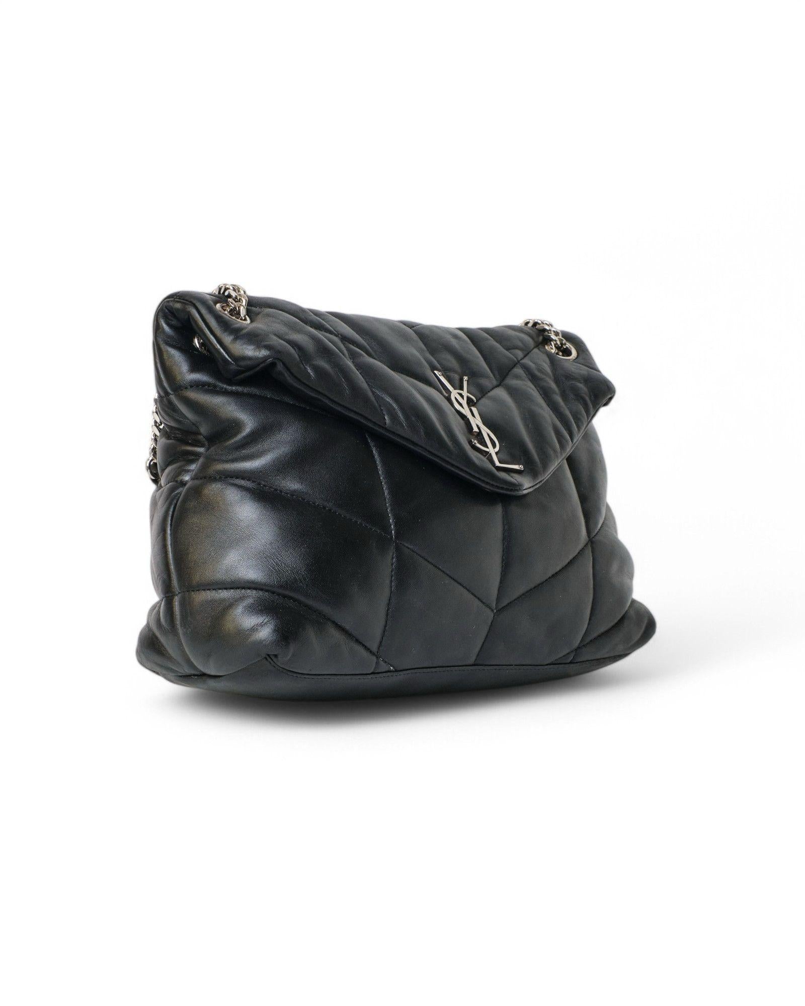Sac signé Saint Laurent, modèle LouLou Puffer en taille moyenne, en cuir d'agneau noir avec ferrures argentées. Doté d'un rabat orné du logo YSL classique en métal argenté et d'une fermeture à bouton aimanté, il est doublé à l'intérieur en toile ton