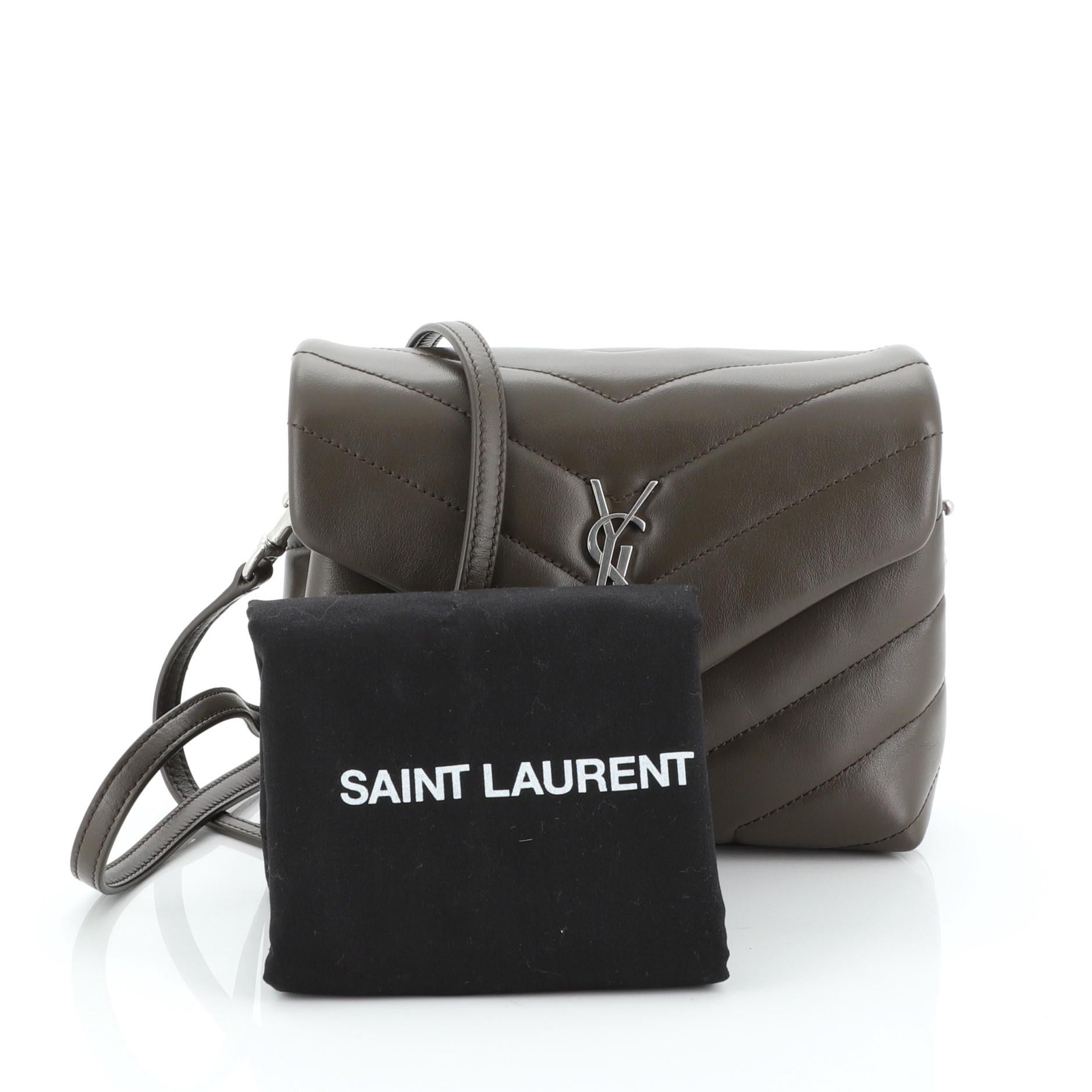 This Saint Laurent LouLou Shoulder Bag Matelasse Chevron Leather Toy, crafted in neutral matelasse chevron leather, features a long leather strap and silver-tone hardware. Its magnetic snap closure opens to a black fabric interior divided into two