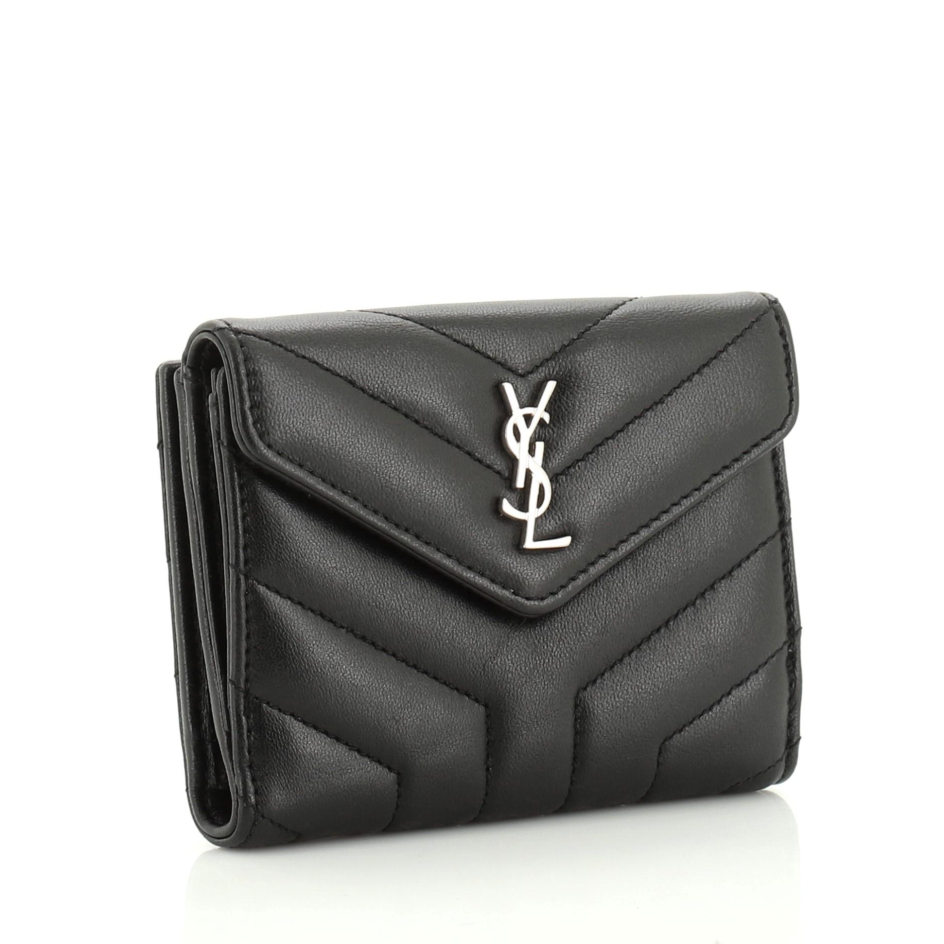 This Saint Laurent Loulou Wallet Matelasse Chevron Leather Small, crafted in black matelasse chevron leather, features envelope flap design with YSL logo and silver-tone hardware. Its snap button closure opens to a black leather interior with