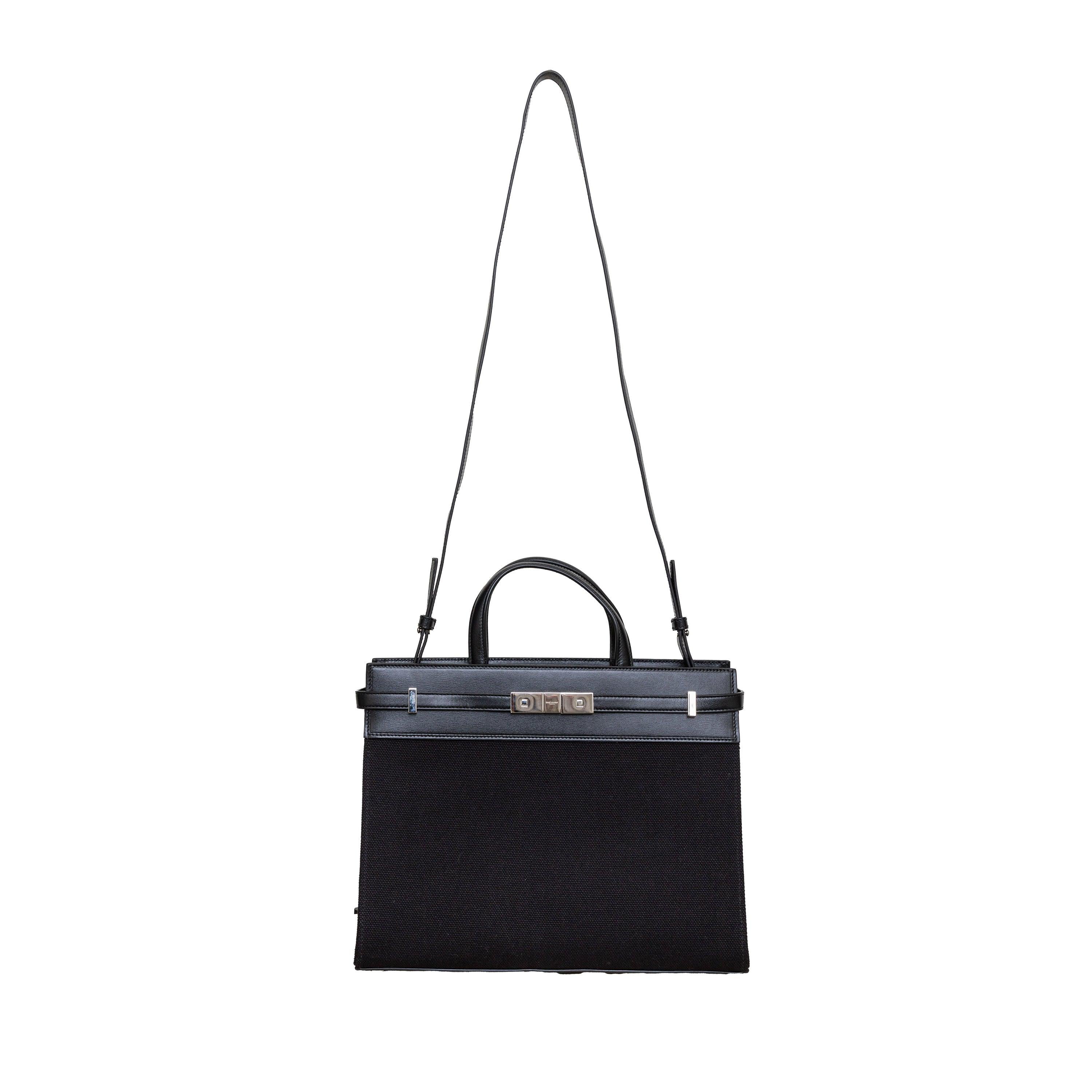 The Saint Laurent Manhattan Tote Bag is a must-have for any fashion-forward individual. Crafted from durable black canvas with luxurious leather trimming, this bag boasts a decadent aesthetic. With twin top handles and a removable, adjustable strap,