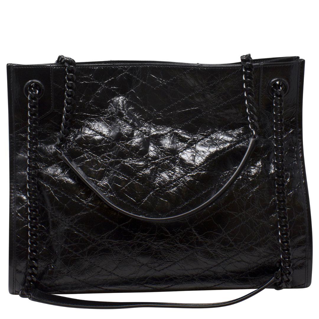 Casual, effortles, chic, are just a few ways to describe this gorgeous Niki bag! Featuring top shoulder straps in a gorgeous gunmetal chain, this bag has a a quilted effect, silver-tone hardware and a tonal YSL logo appliqué on the front. The open