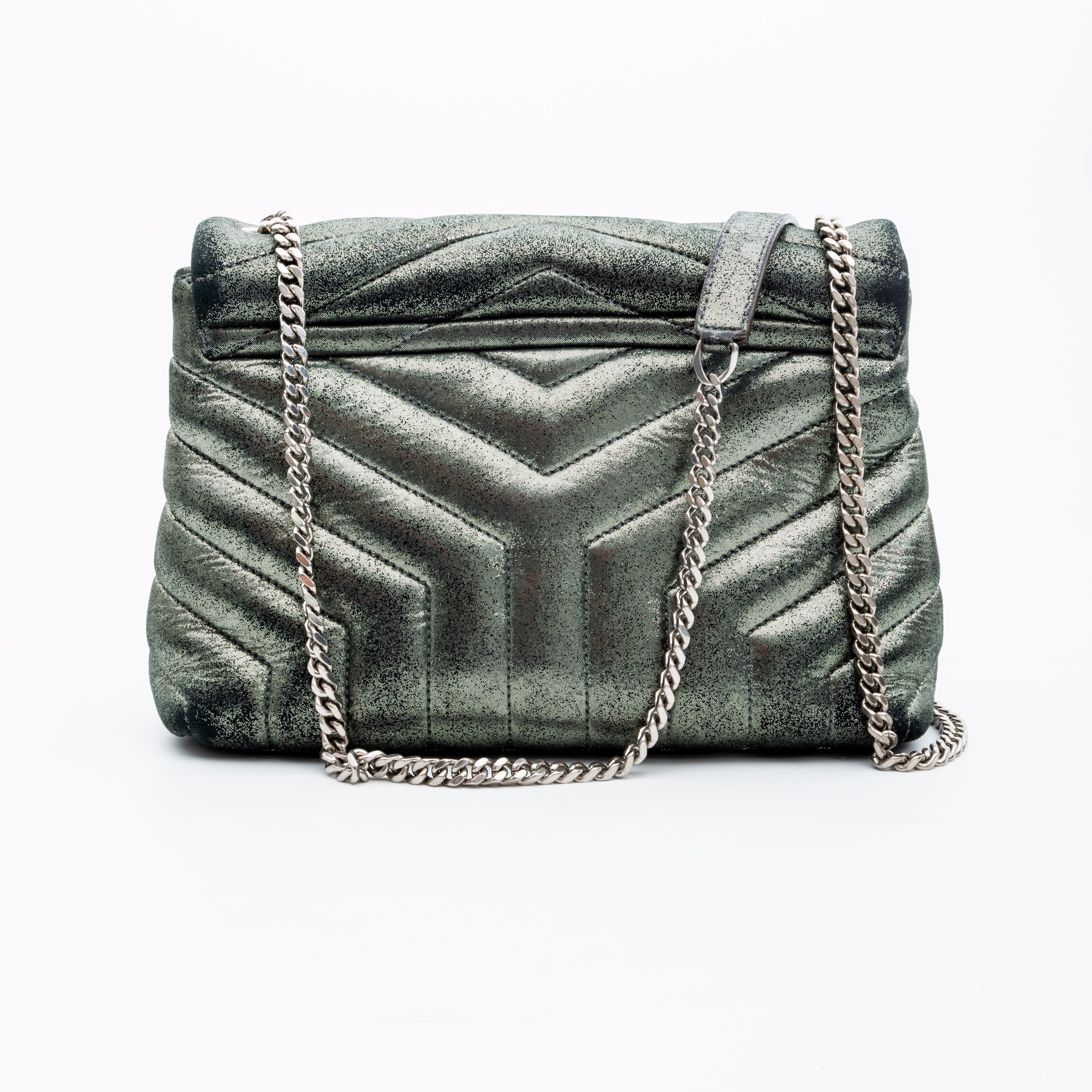 Questa borsa a tracolla è realizzata in pelle di vitello con cuciture matelassé e trapuntate chevron in colore argento metallizzato. La borsa presenta una tracolla a catena color canna di fucile, una tracolla in pelle abbinata, un dettaglio