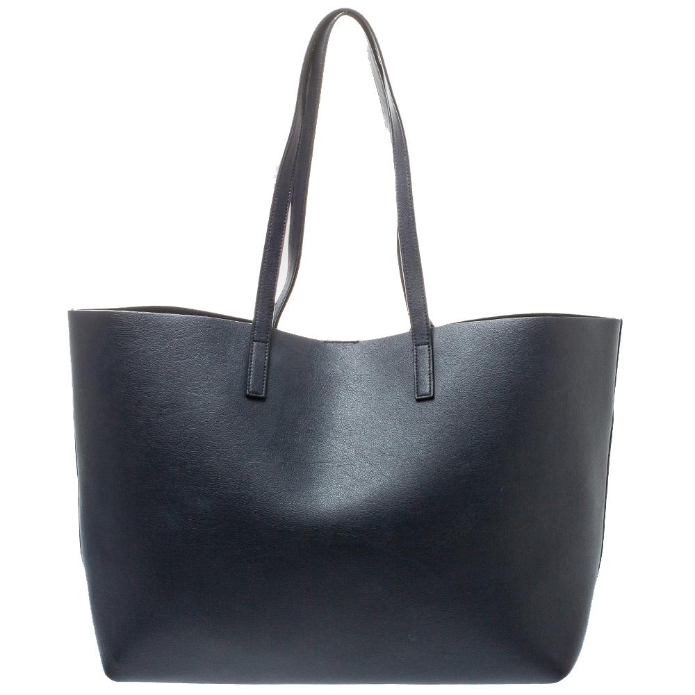 Totes are forever in style and this midnight blue leather E/W Shopper tote by Saint Laurent is a class apart. It contains a spacious compartment, two handles, and the brand label on the front. The beauty is a perfect bag for everyday
