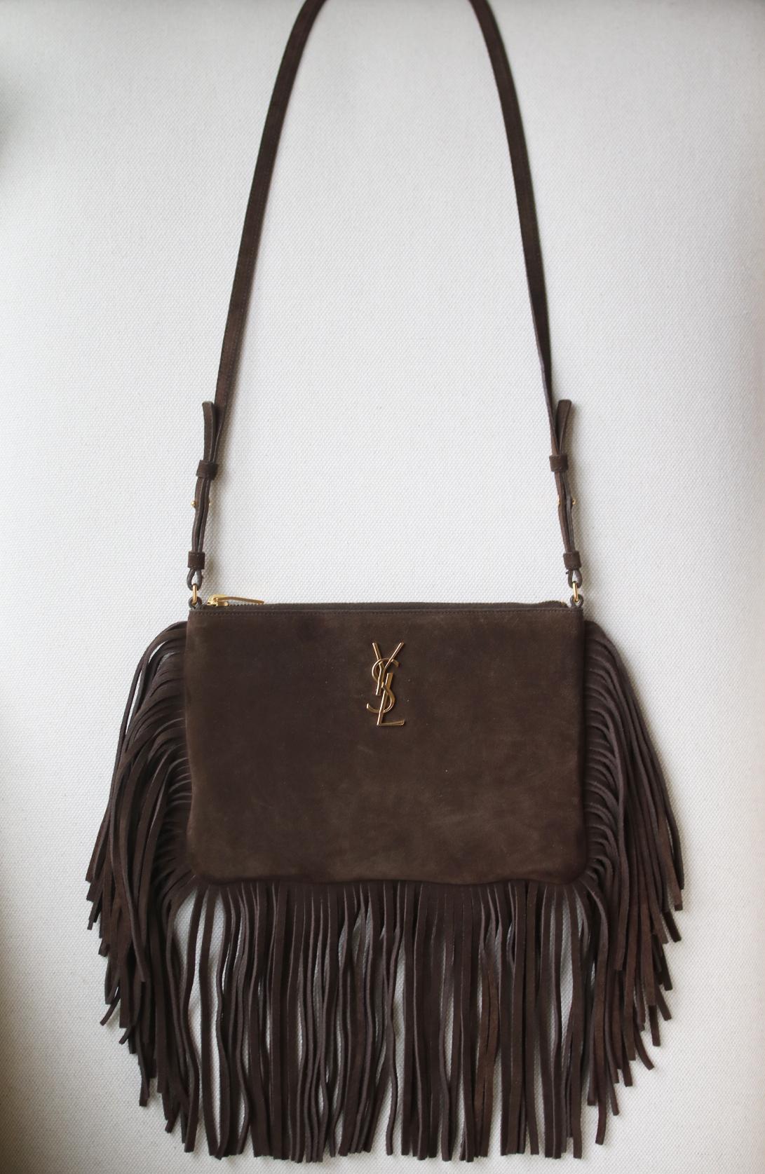 Saint Laurent fringe bag with metal interlocking YSL signature and removable, adjustable shoulder strap. Gold-tone hardware.  6 interior card slots, 2 slot pockets. Zip top closure. Grosgrain lining. 100% Calfskin. Colour: brown. Made in Italy. Does