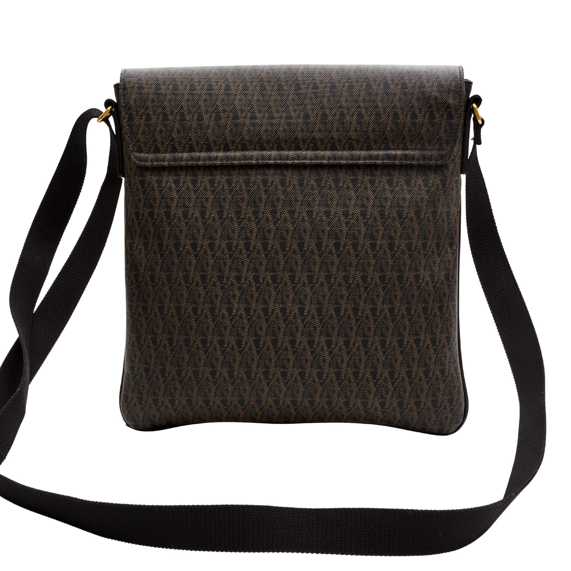 This flat messenger Crossbody bag is made with brown coated canvas with leather detail and a woven fabric shoulder strap. The bag features a front flap with magnetic closure and black woven fabric interior lining with a slip pocket.

COLOR: