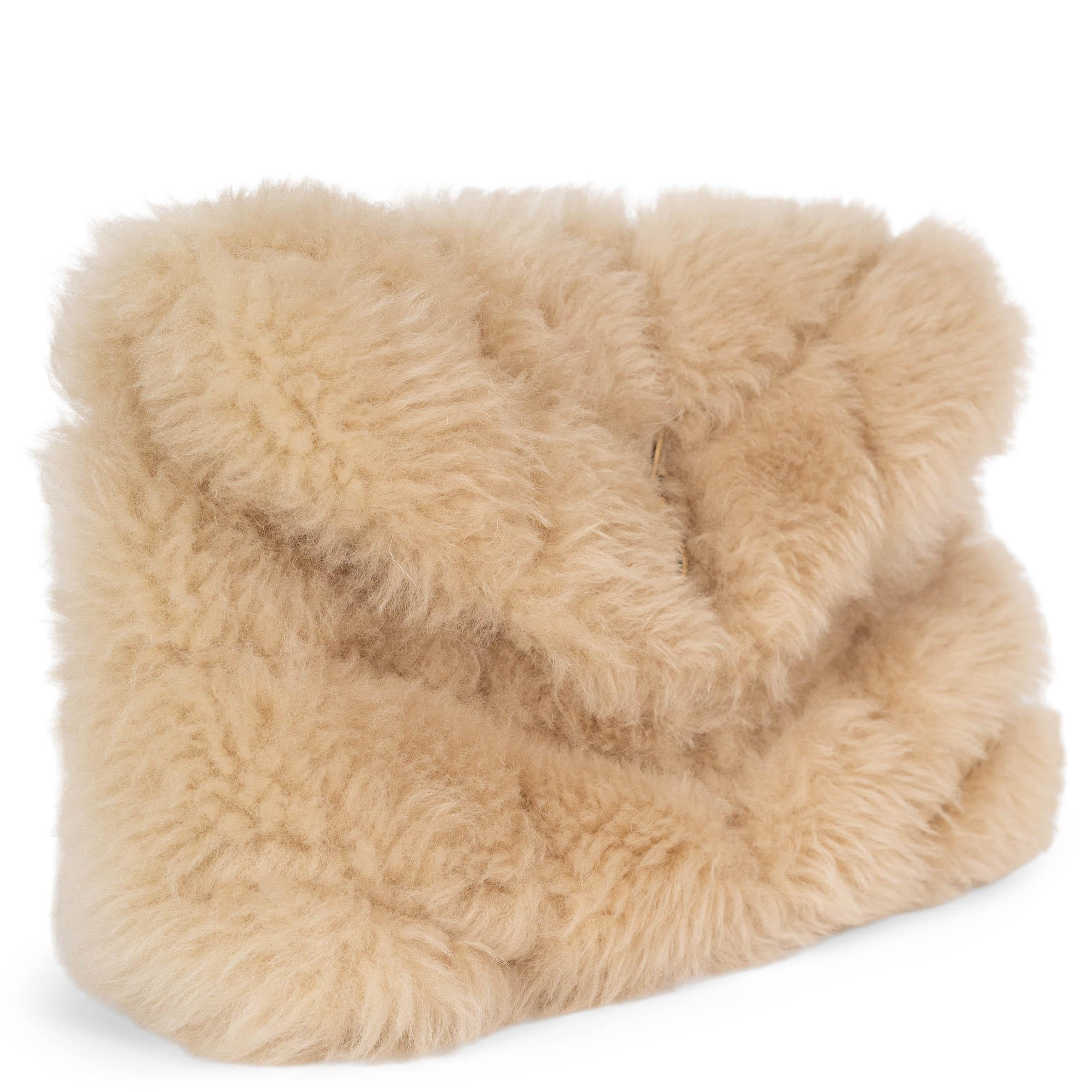This 100% authentic Saint Laurent Puffer Small Clutch in natural beige quilted shearling exudes effortless sophistication with a cozy, luxurious touch. Featuring the iconic gold-tone YSL monogram on the flap, this statement piece balances elegance