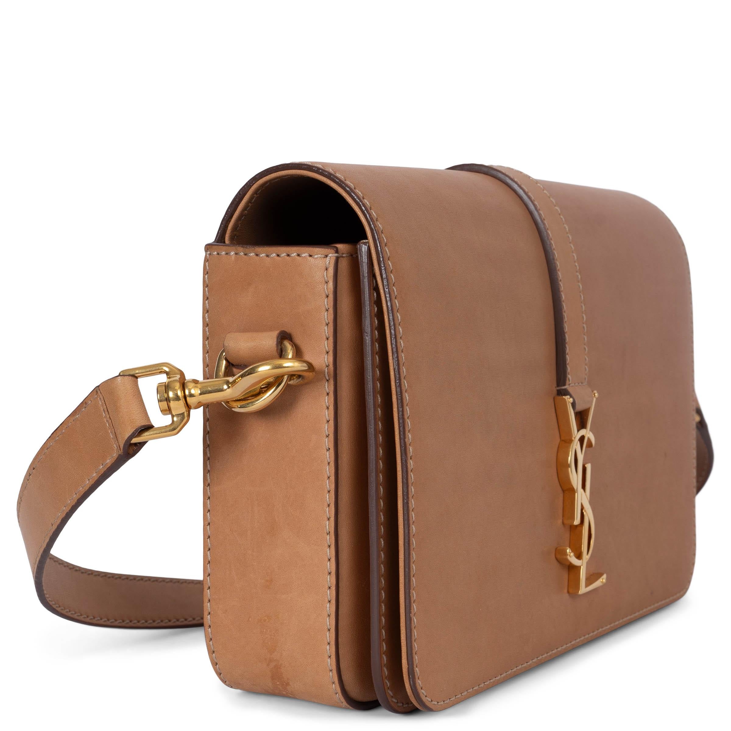 Bandolera mediana Monograma Université 100% auténtica Saint Laurent de piel de becerro lisa natural con herrajes dorados. Se abre con un botón magnético bajo la solapa y está forrada de ante marrón camel con un bolsillo con cremallera en la parte