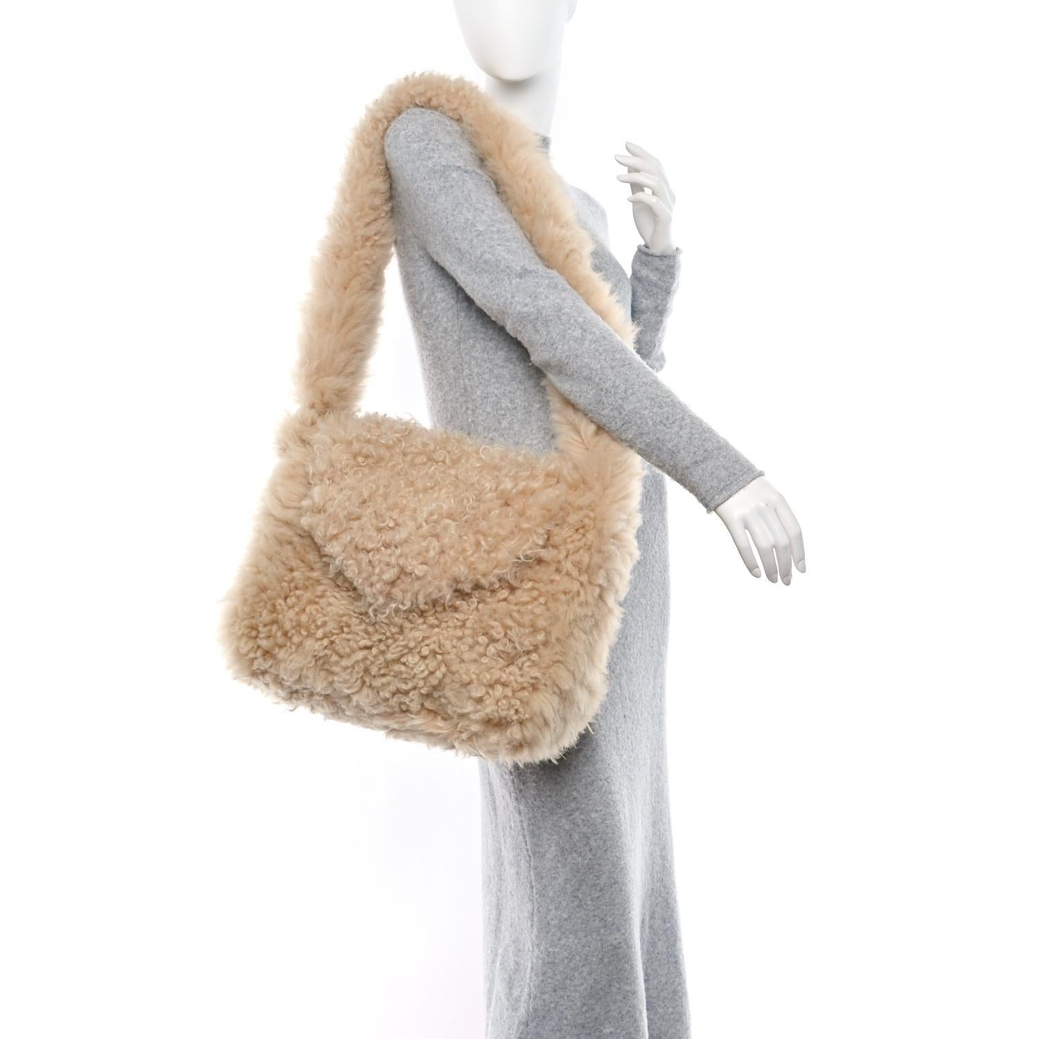 BOLSO SOBRE DE PIEL DE OVEJA NATURAL SAINT LAURENT

Este bolso bandolera Saint Laurent está confeccionado en shearling natural con ribetes de piel marrón y presenta herrajes en tono dorado envejecido. El diseño incluye una bandolera de cadena de