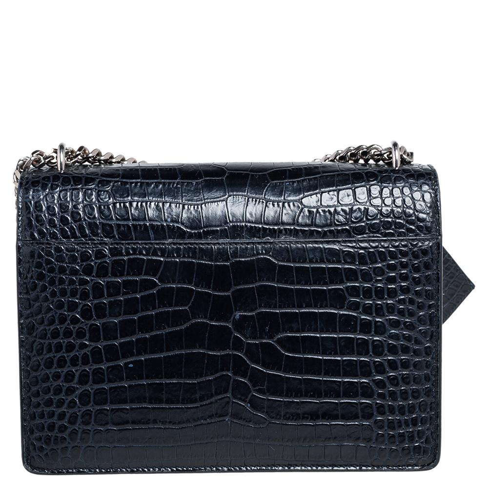 Fall in love with this Sunset bag from Saint Laurent! Crafted from croc-embossed leather, it flaunts the 'YSL' logo on the front flap in silver-tone metal. It has a spacious plush suede-lined interior that houses pockets. This navy blue beauty is