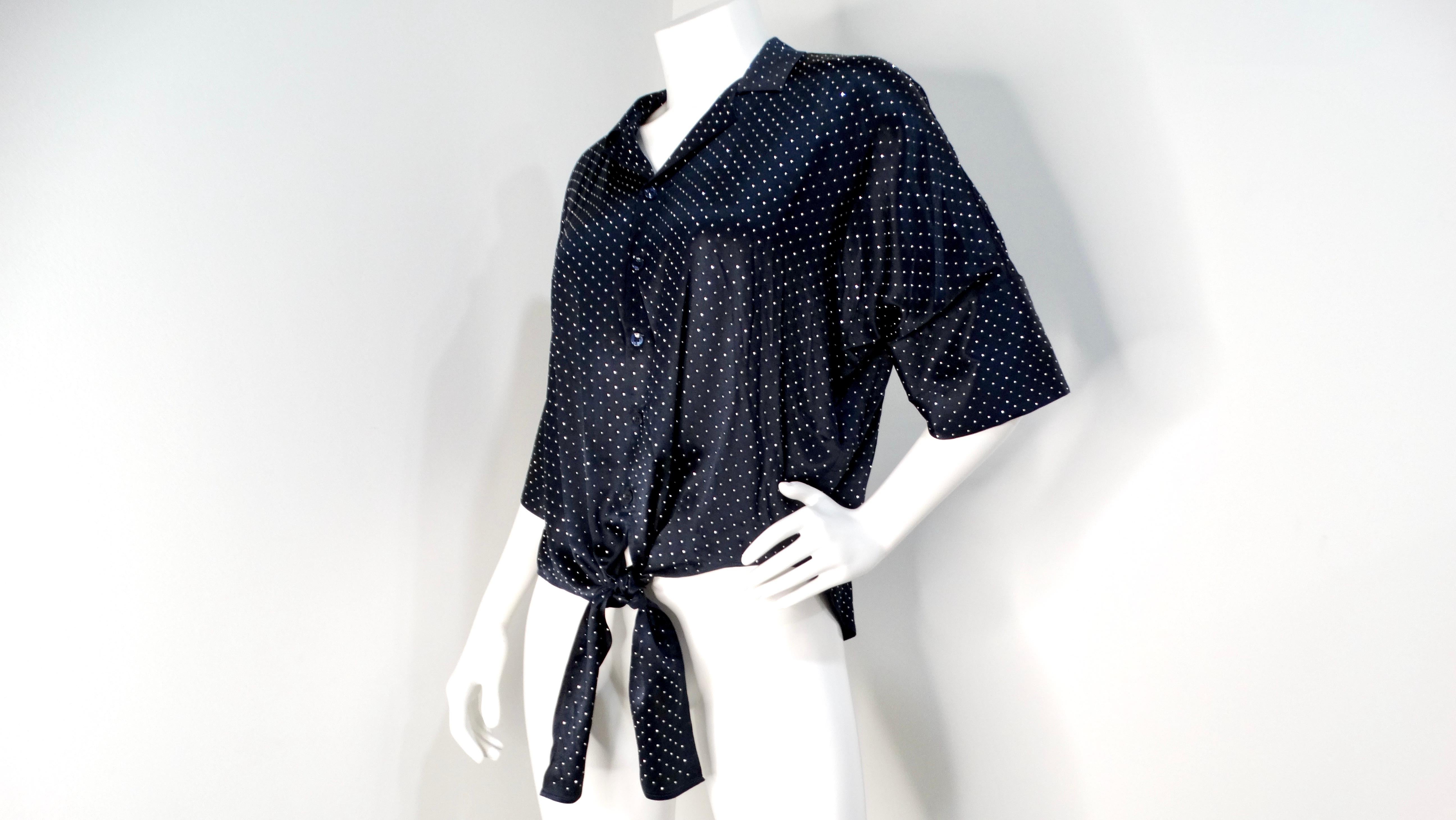 Die marineblaue Seidenbluse mit Knopfleiste und silbernen Nieten von Saint Laurent ist eine moderne Interpretation des klassischen Button-up-Hemdes, die Eleganz und zeitgenössisches Flair vereint. Diese Bluse aus luxuriöser marineblauer Seide ist