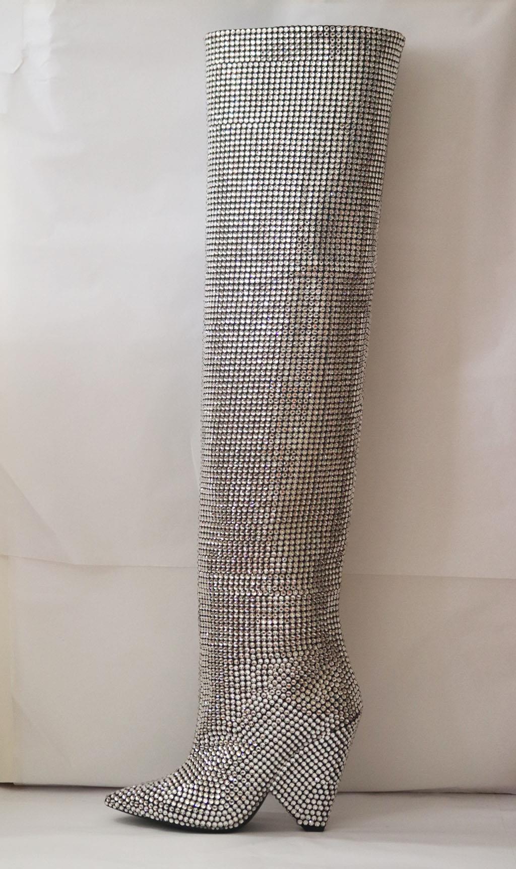 The 'Niki' knee boots grounded most of the looks on Saint Laurent's runway, made from supple black leather that slouches into soft folds, they have been handcrafted in Italy and encrusted with 3000 Austrian crystals that cover even the signature
