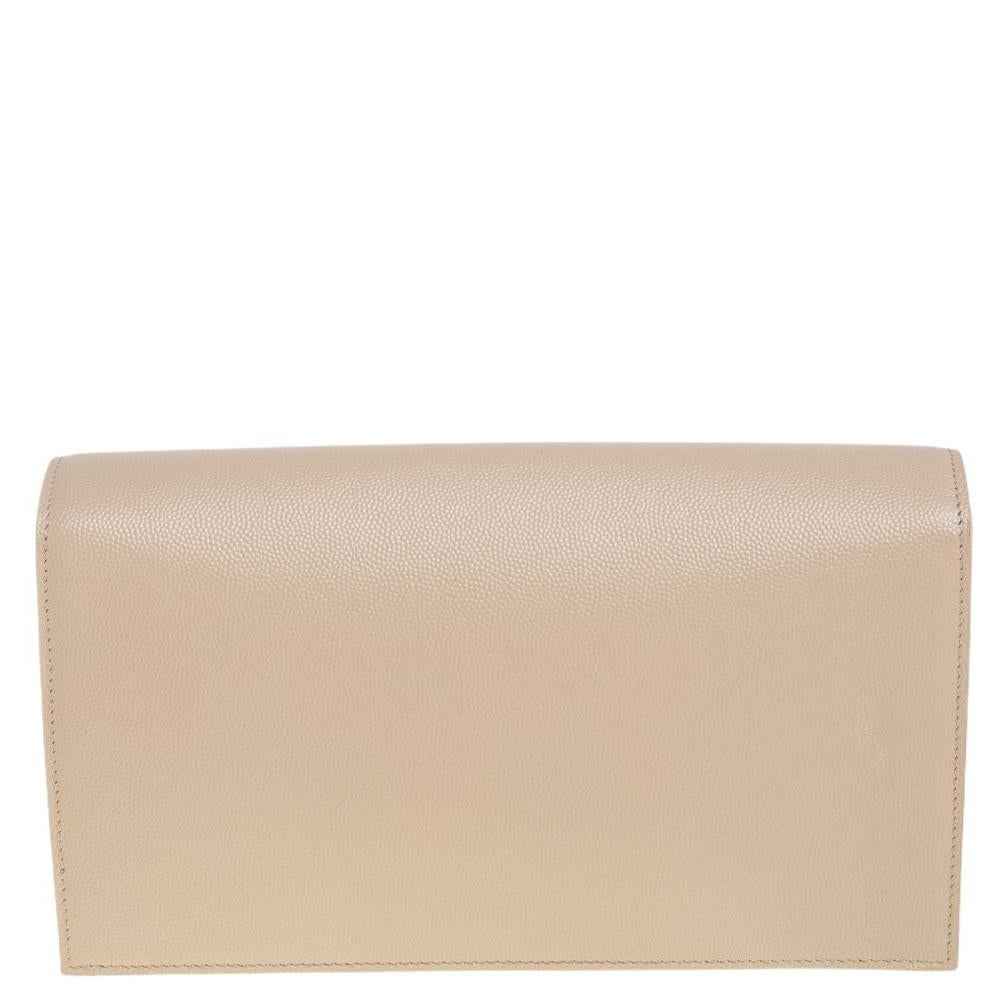 Meticulously crafted from classic nude leather, this Saint Laurent Kate clutch exudes just the right amount of sophistication! The bag features the YSL logo on the front flap and a fabric & leather-lined compartment to store your essentials. Carry