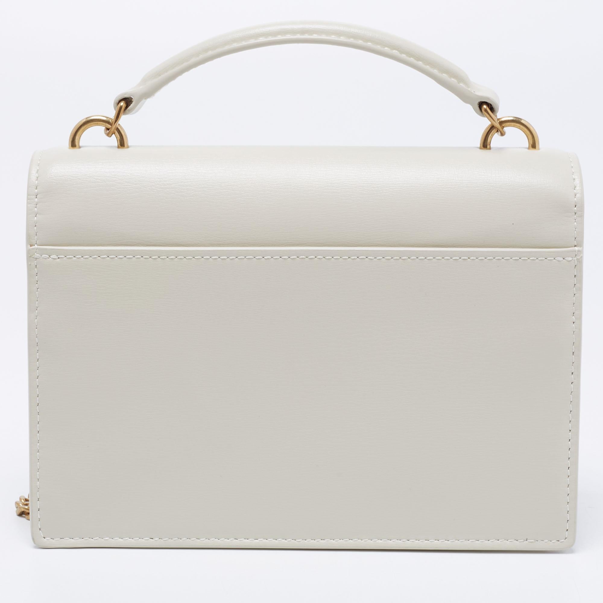 Fall in love with this Sunset bag from Saint Laurent! Crafted from quality leather, it flaunts the 'YSL' logo on the front flap in gold-tone metal. It has a spacious leather-lined interior that houses pockets. This off-white beauty is complete with