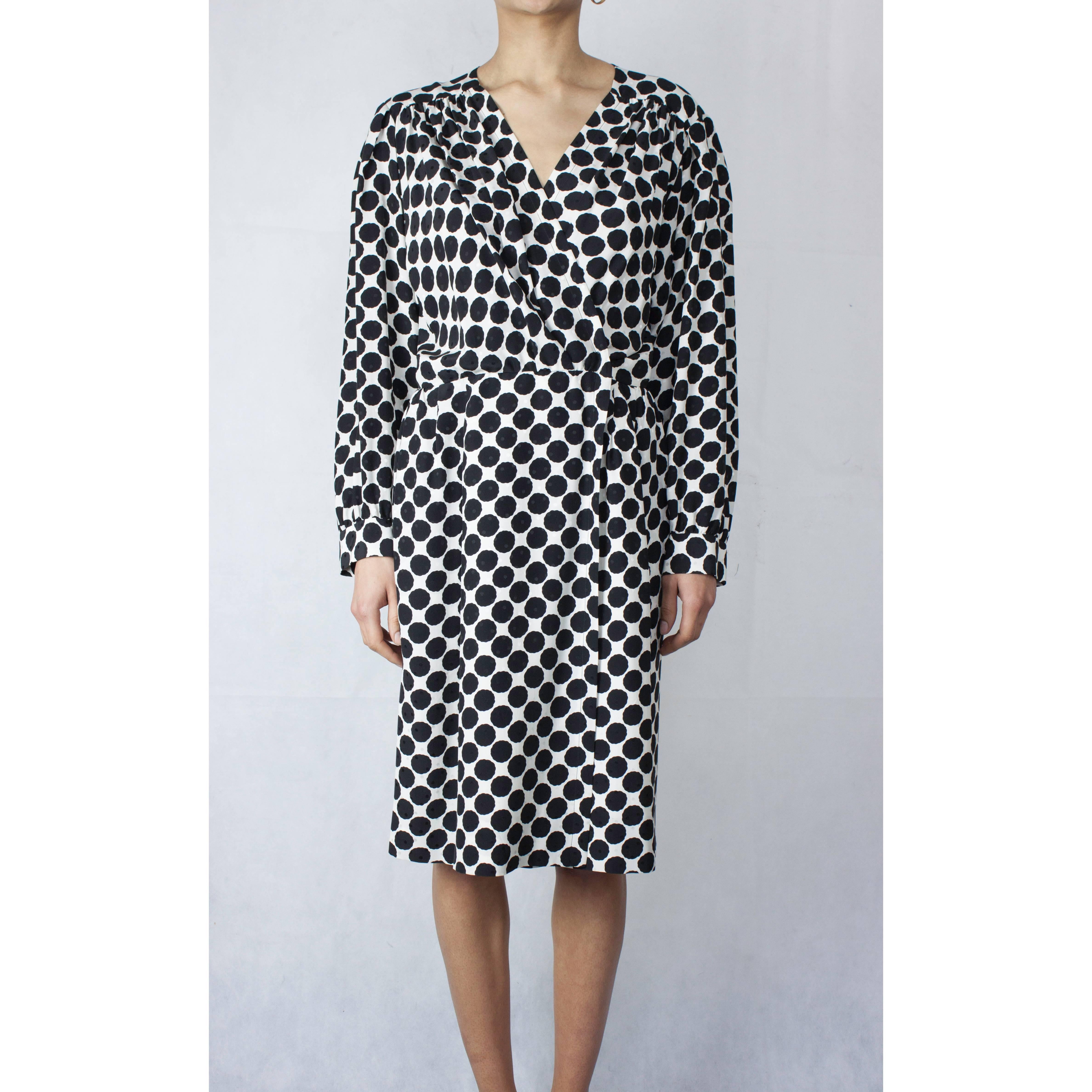 
This elegance and feminine Saint Laurent dress is constructed from embossed silk dress with black polka dots on white background. Featuring a V-neckline with gathered shoulders and long sleeves with barrel sleeves. Two large darts adorn the back of