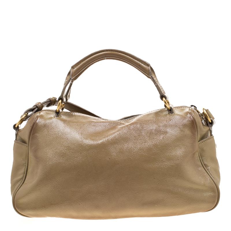 Carefully made to evoke a fashionable feel, this patent leather bag is sure to make heads turn. This beige satchel has two top handles, a detachable shoulder strap and a front flap closure that secures the slide pocket with a gold-tone twist lock.