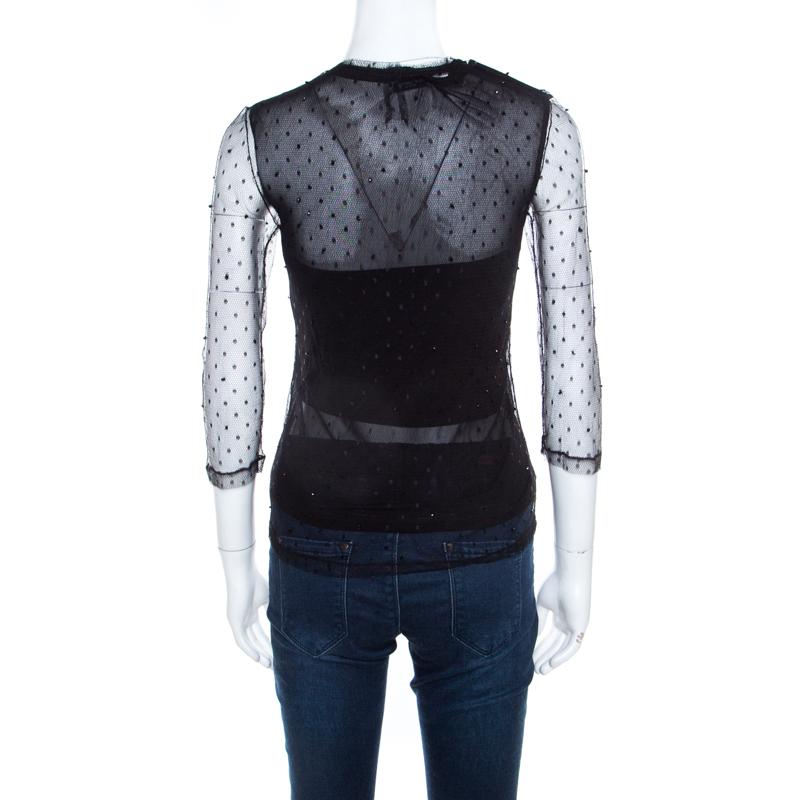 This black creation from Saint Laurent Paris features flattering feminine details. It flaunts a mesh body enhanced with bead embellishments. It comes with a round neckline and quarter sleeves. It'll look fabulous with slim fit jeans and pointed