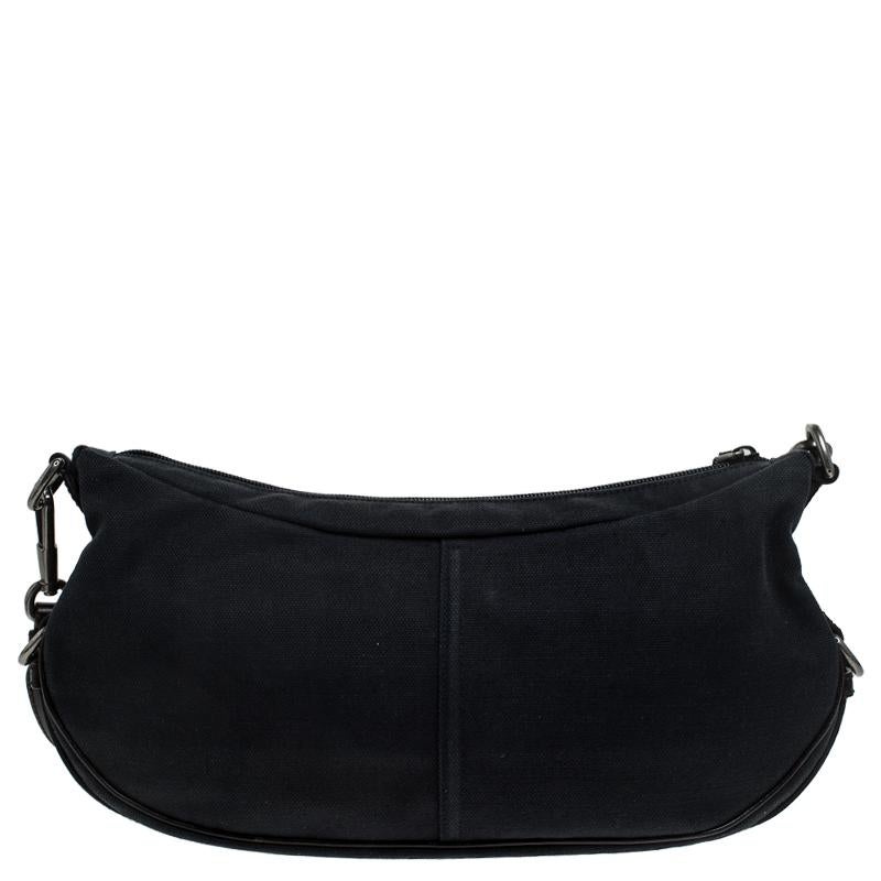 Saint Laurent Paris has infused interesting, unique details in this notable Mombasa bag. It is made of black canvas with protective leather trim outlining the bag. A signature of the Mombasa style, the bag has a horn detail on the shoulder strap