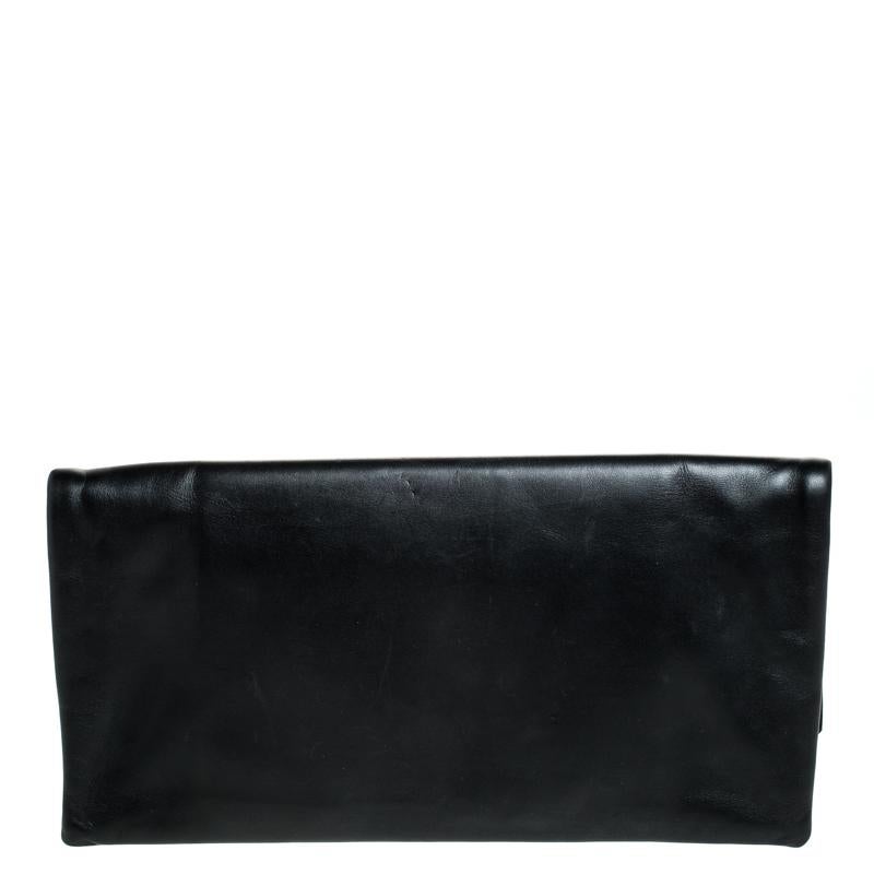 Dress it up for those day parties and events, this beautiful Saint Laurent Paris flap clutch is perfect to add a touch of sophistication to your look. Crafted in black leather, this bag is designed with a gold-tone metal detailed cutout at the flap