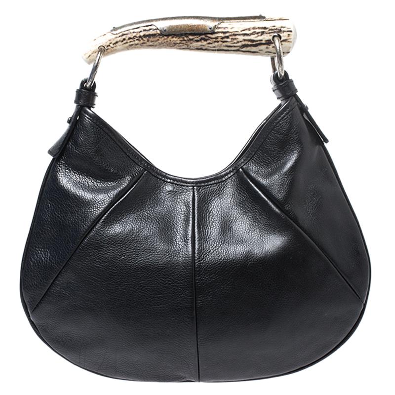 Accessorize your outfit with a Saint Laurent Paris bag like this and make a style statement. It has been crafted from black leather and designed with a spacious suede interior and a horn handle. It is finished with silver-tone hardware. Carefully