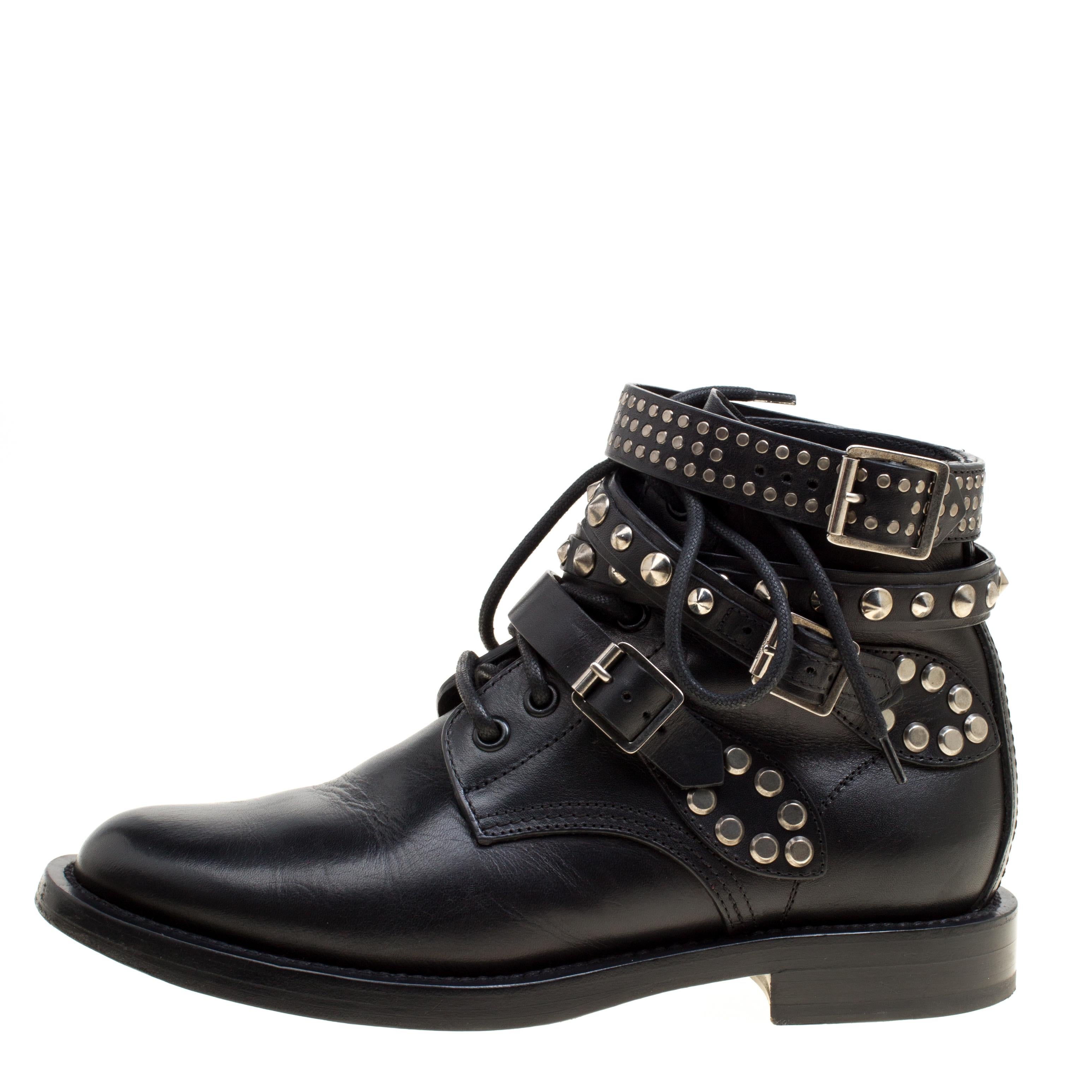 These Rangers ankle boots by Saint Laurent Paris will transform your looks with sophistication and class. They have a black leather exterior with belted straps accented with studs on the ankles. They feature almond toes along with lace-ups on the