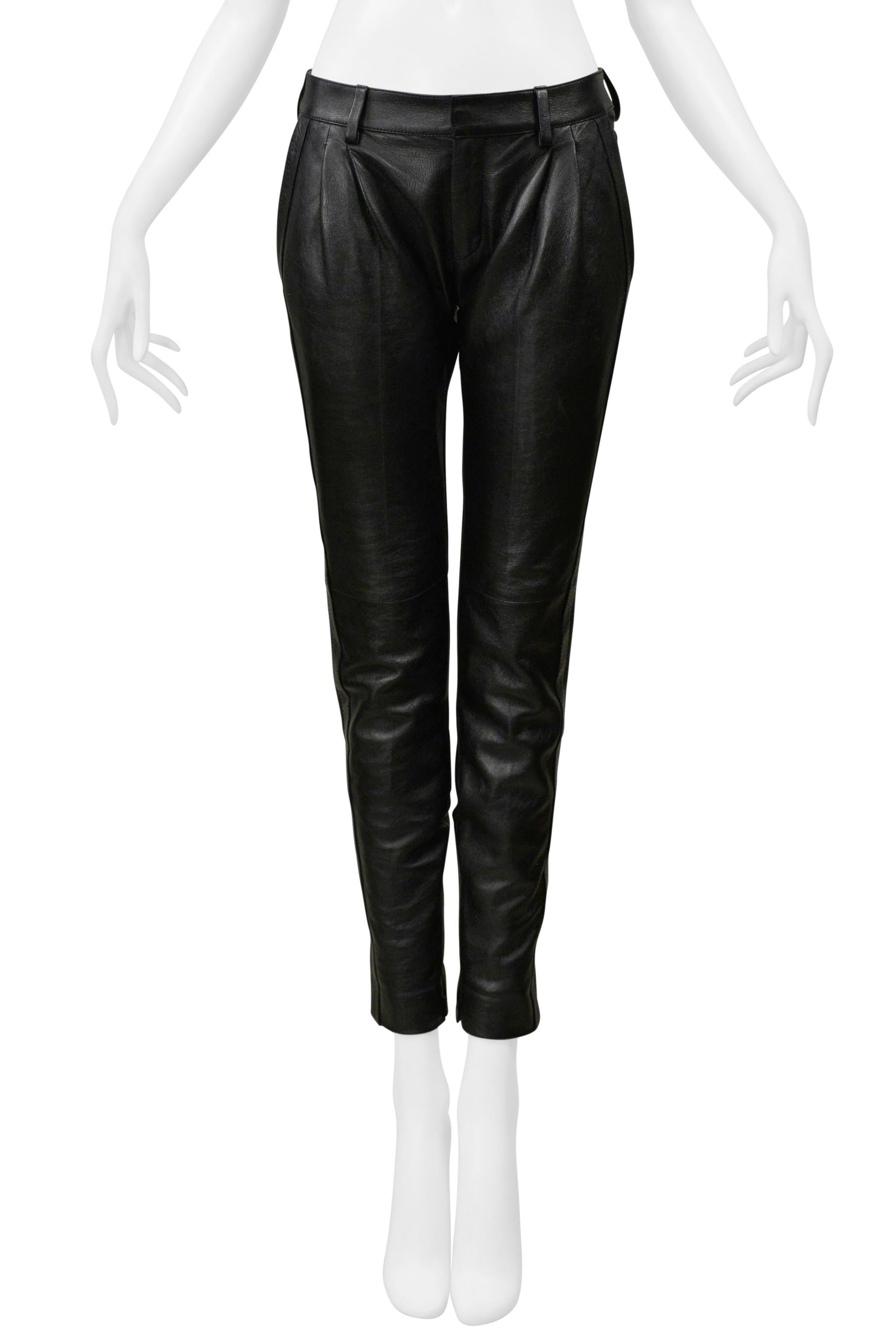 Resurrection Vintage ist begeistert, ein Paar schwarze Lederhosen von Saint Laurent Paris zu präsentieren. Sie haben Falten auf der Vorderseite, Seitentaschen, Seidenfutter, Knöchelreißverschlüsse und einen Reißverschluss in der Mitte.  

Saint