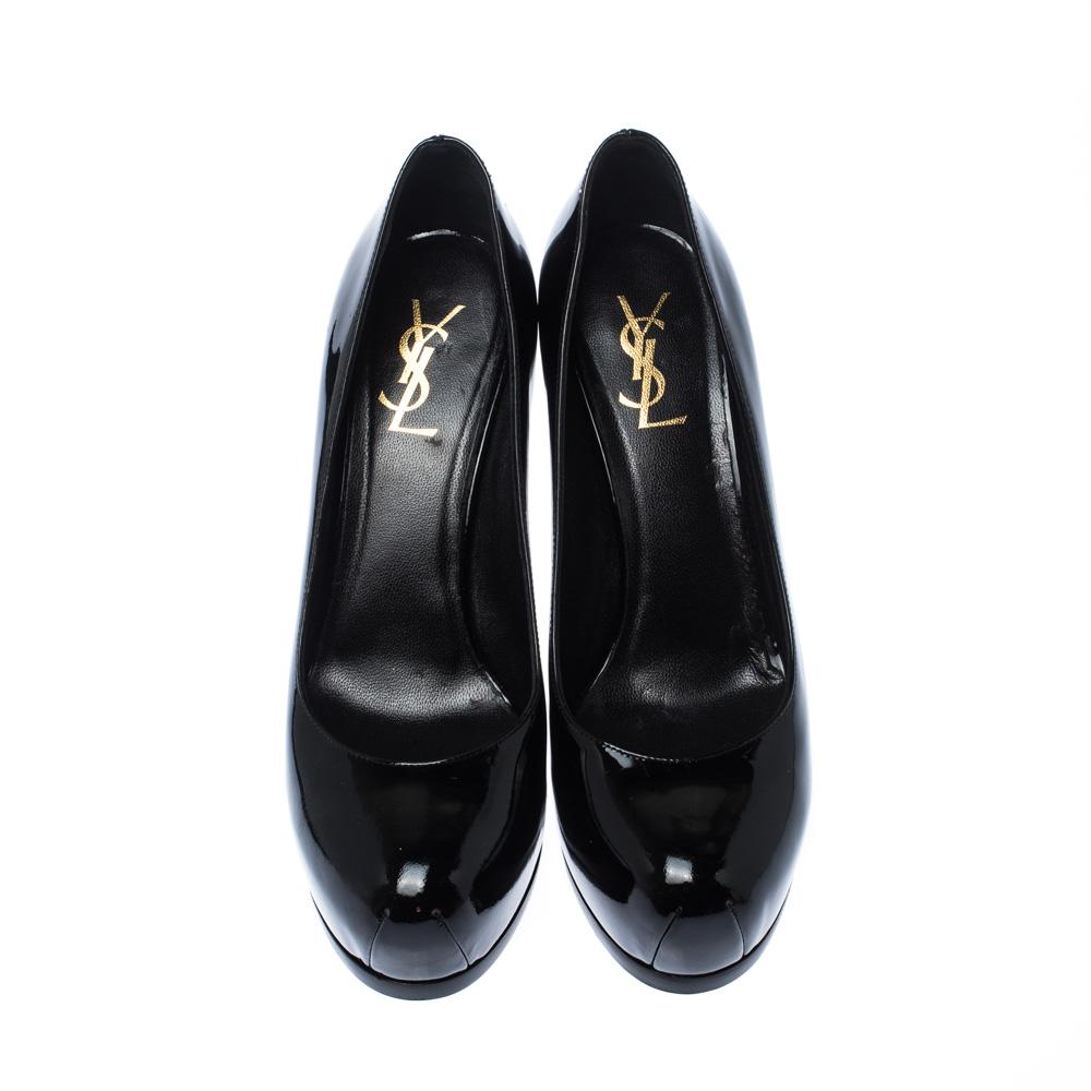 This amazing pair of black pumps is from Saint Laurent Paris. They have been crafted from shiny patent leather and styled with round toes. The Tribute pumps come with stylishly-carved platforms, comfortable insoles, and 11cm high stiletto heels. Don