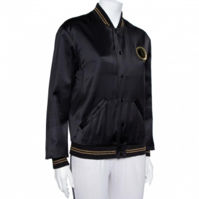 Look stylish and modern this season with this cool Saint Laurent Paris jacket. Sleek and elegant is this black satin jacket. It is detailed with contrasting lurex trims, button fastenings, two pockets, and long sleeves.