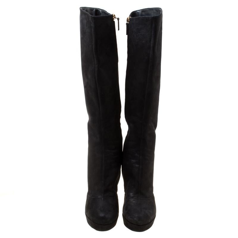 This lovely pair of Saint Laurent boots has a stylish silhouette and simple design. The knee-high boots have been crafted from black shimmering suede and will look lovely with a short leather skirt and high-neck sweater. Complete with almond toes,