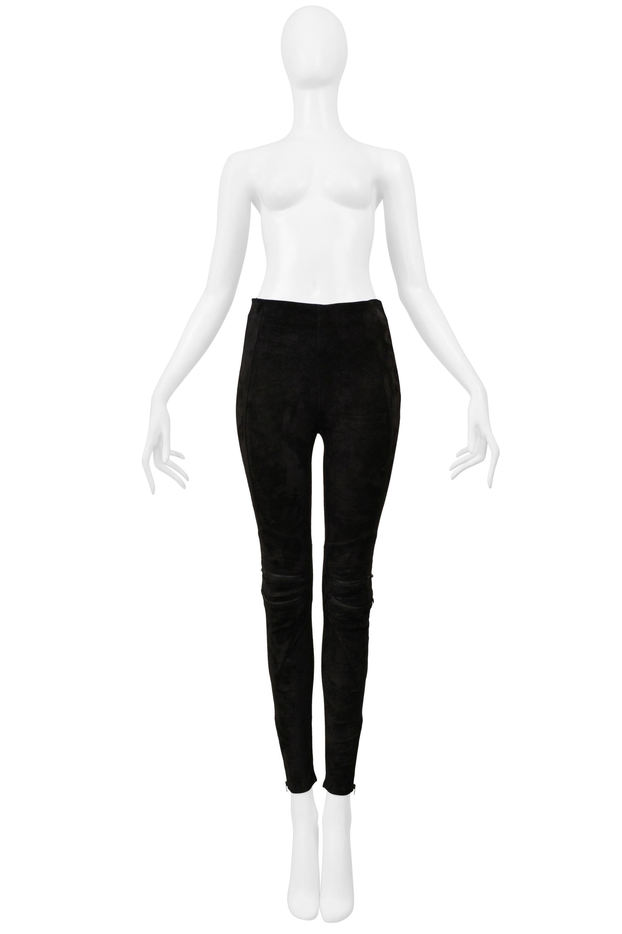 Resurrection Vintage è entusiasta di presentare un paio di pantaloni Saint Laurent Paris in pelle scamosciata nera elasticizzata con dettagli moto cuciti sulle ginocchia con cerniere, vestibilità slim, cerniere alla caviglia e cerniera