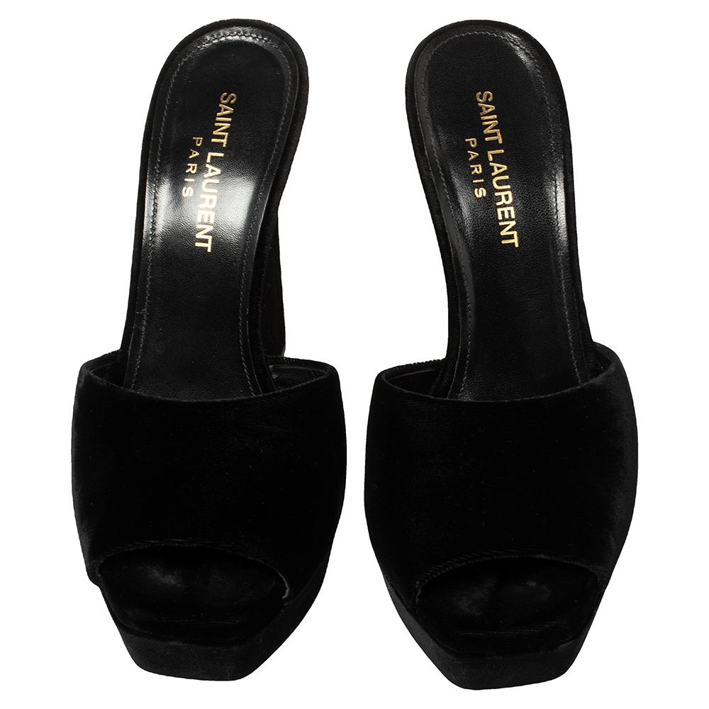 We are in utter awe of Saint Laurent Paris' minimal yet glamorous sandals. Crafted from smooth velvet in a black shade, they feature a broad strap that elegantly wraps around the foot and forms an open-toe silhouette. These sandals are elevated on