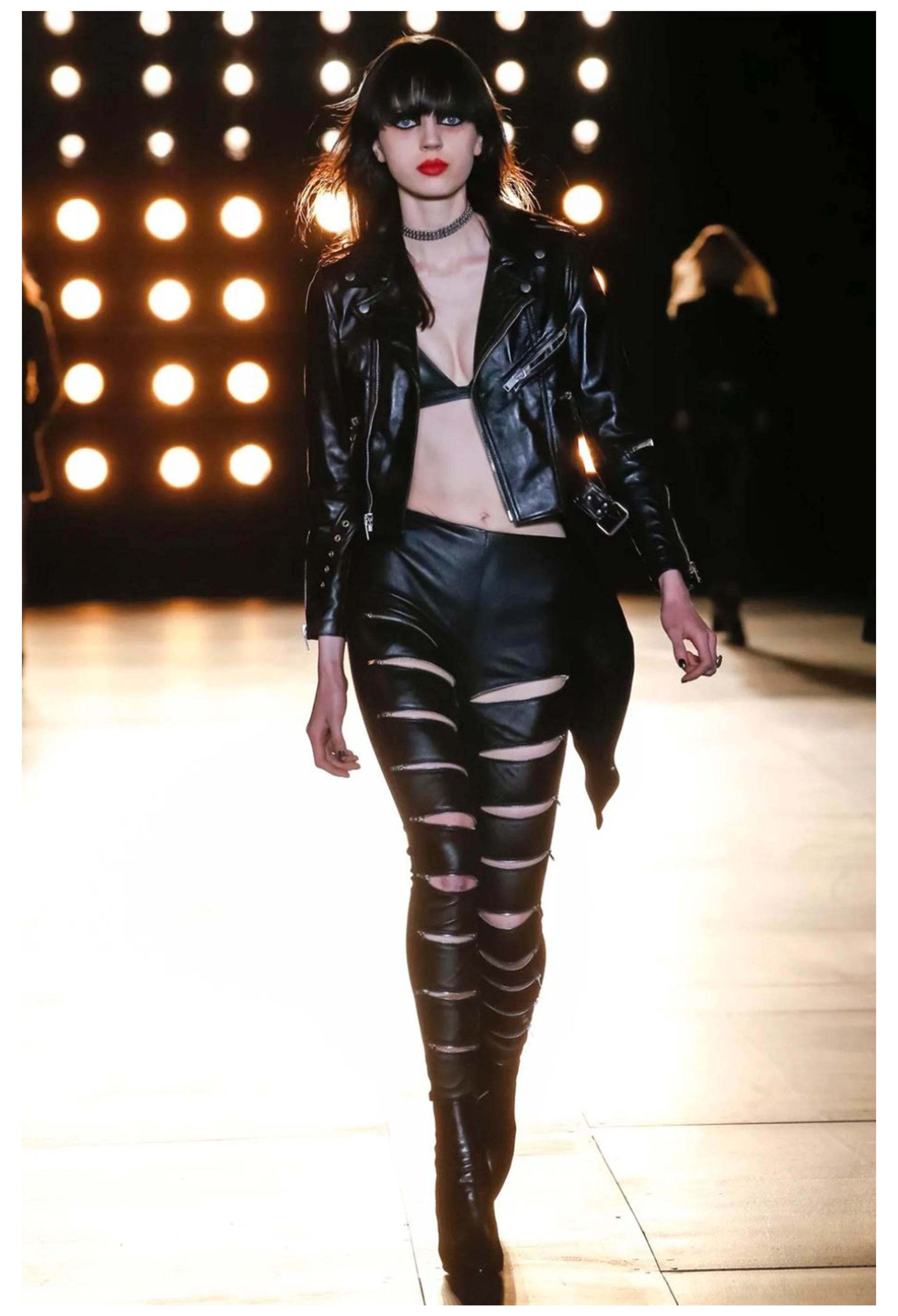 Resurrection Vintage è entusiasta di presentare un paio di pantaloni Saint Laurent Paris in pelle nera con spacchi lungo le cosce, vestibilità slim, cerniere alle caviglie, passanti per la cintura e lunghezza alla caviglia. 

Saint Laurent Parigi