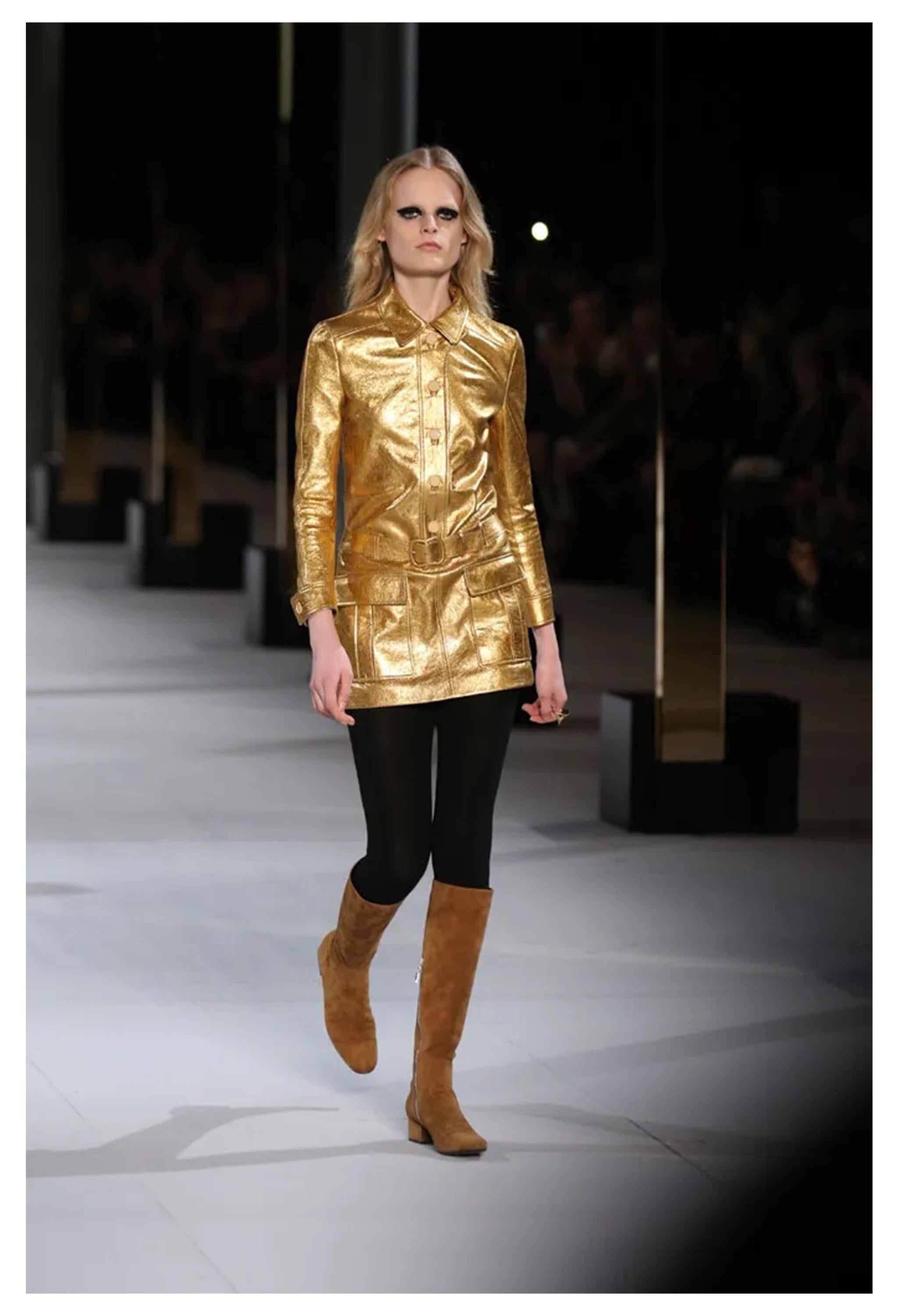 Resurrection is thrilled to present a stunning Saint Laurent Paris by Hedi Slimane gold leather moto dress featuring a button front placket, hip pockets, belt and buckle and mini length. 

Saint Laurent Paris
Designed By Hedi Slimane 
Size: