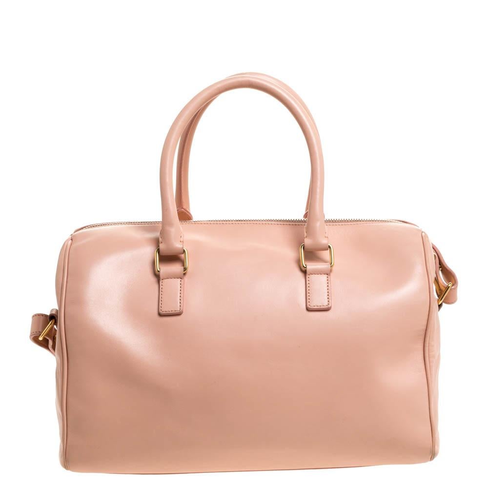 Bet it for an easy travelling experience or everyday use, this Classic Duffle from Saint Laurent is perfect! It is crafted from coral orange leather and designed with two top handles, a shoulder strap and a well-sized suede