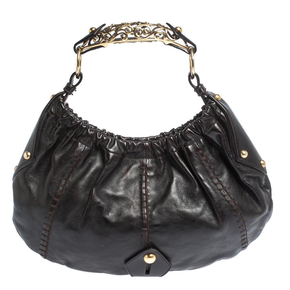Don't miss out on your chance to own this rare Saint Laurent Paris Vincennes Mombasa Hobo. Made from gorgeous dark brown leather and a metal horn-shaped handle, it is accented with gold-tone hardware and a small pouch. Enclosed with a snap magnetic