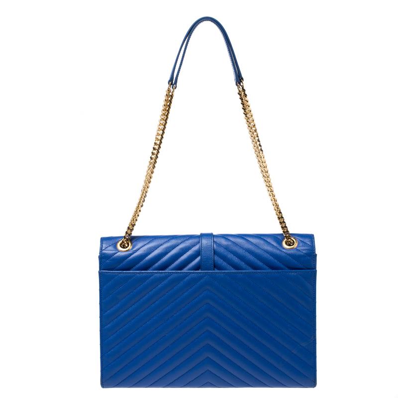 This exquisite Cassandre bag from Saint Laurent Paris is a chic accessory that represents the brand's rich aesthetics and elegant designs. Crafted from blue leather, this easy-to-carry bag has a flap style with the YSL logo in gold-tone on the