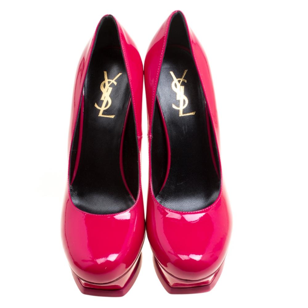 This amazing pair of pink fuchsia pumps is from Saint Laurent Paris. They have been crafted from shiny patent leather and styled with round toes. The Tribute pumps come with stylishly-carved platforms, comfortable insoles, and 14cm high stiletto