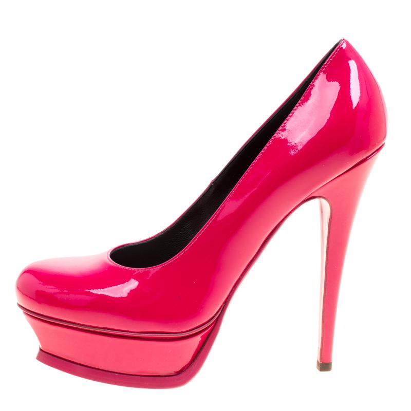 This amazing pair of pink fuchsia pumps is from Saint Laurent Paris. They have been crafted from shiny patent leather and styled with round toes. The Tribute pumps come with stylishly-carved platforms, comfortable insoles, and 14cm high stiletto