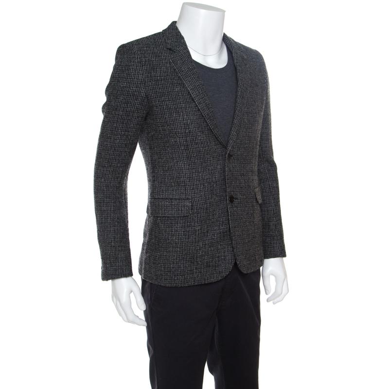Add understated elegance to your formal ensemble with this blazer from Saint Laurent Paris. A well-tailored piece, this one is crafted with wool in a subtle combination of grey and black hues. It has two buttoned closure with stylish lapels and long