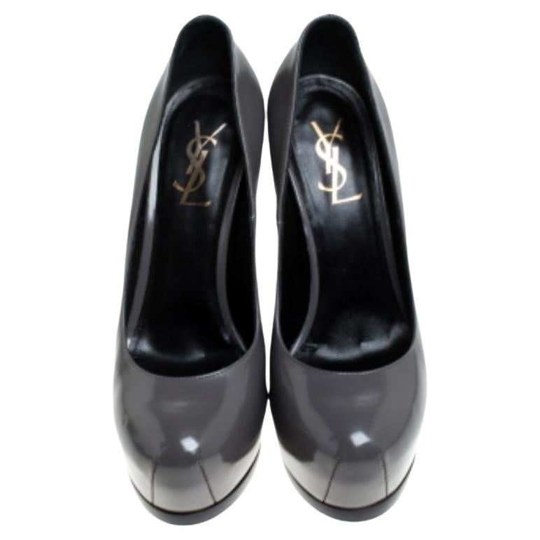 Chic et tendance, ces escarpins Tribtoo de Saint Laurent vous offriront une silhouette séduisante de jour comme de nuit. Confectionnés en cuir verni, ces escarpins brillants présentent une teinte grise douce, des plates-formes dissimulées et des