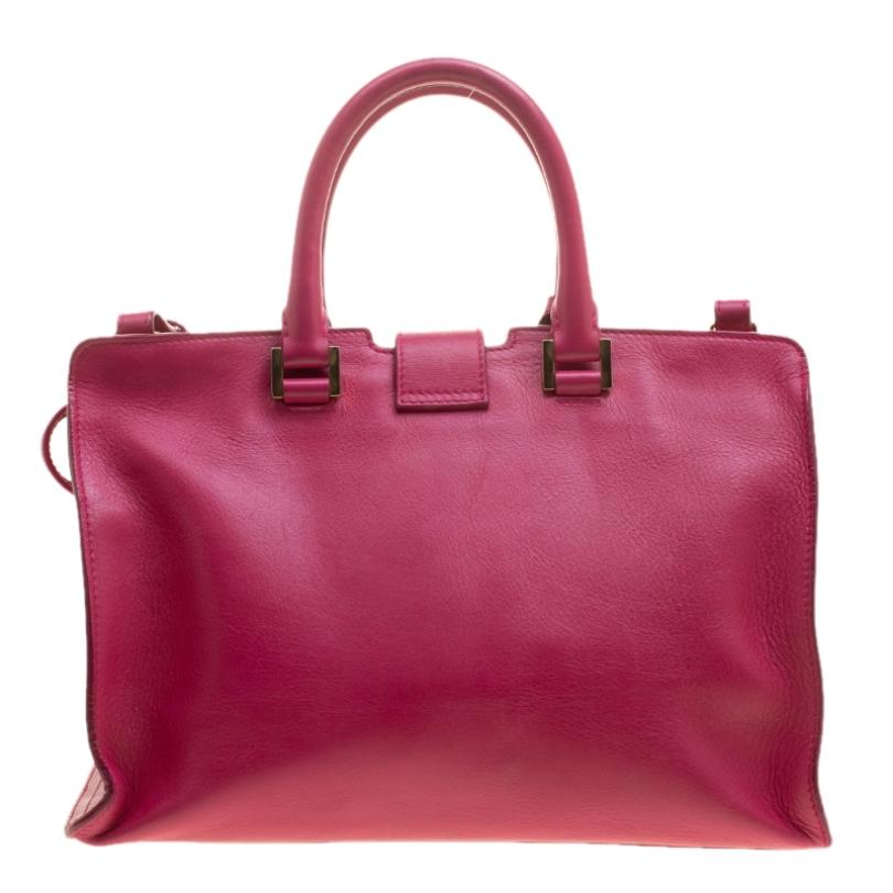 This eye catching hot pink Cabas Chyc tote from Saint Laurent Paris is ideal for everyday use. Crafted from leather, the bag is detailed with a gold tone Y motif snap closure, dual rolled leather handles, a shoulder strap, a leather tag and