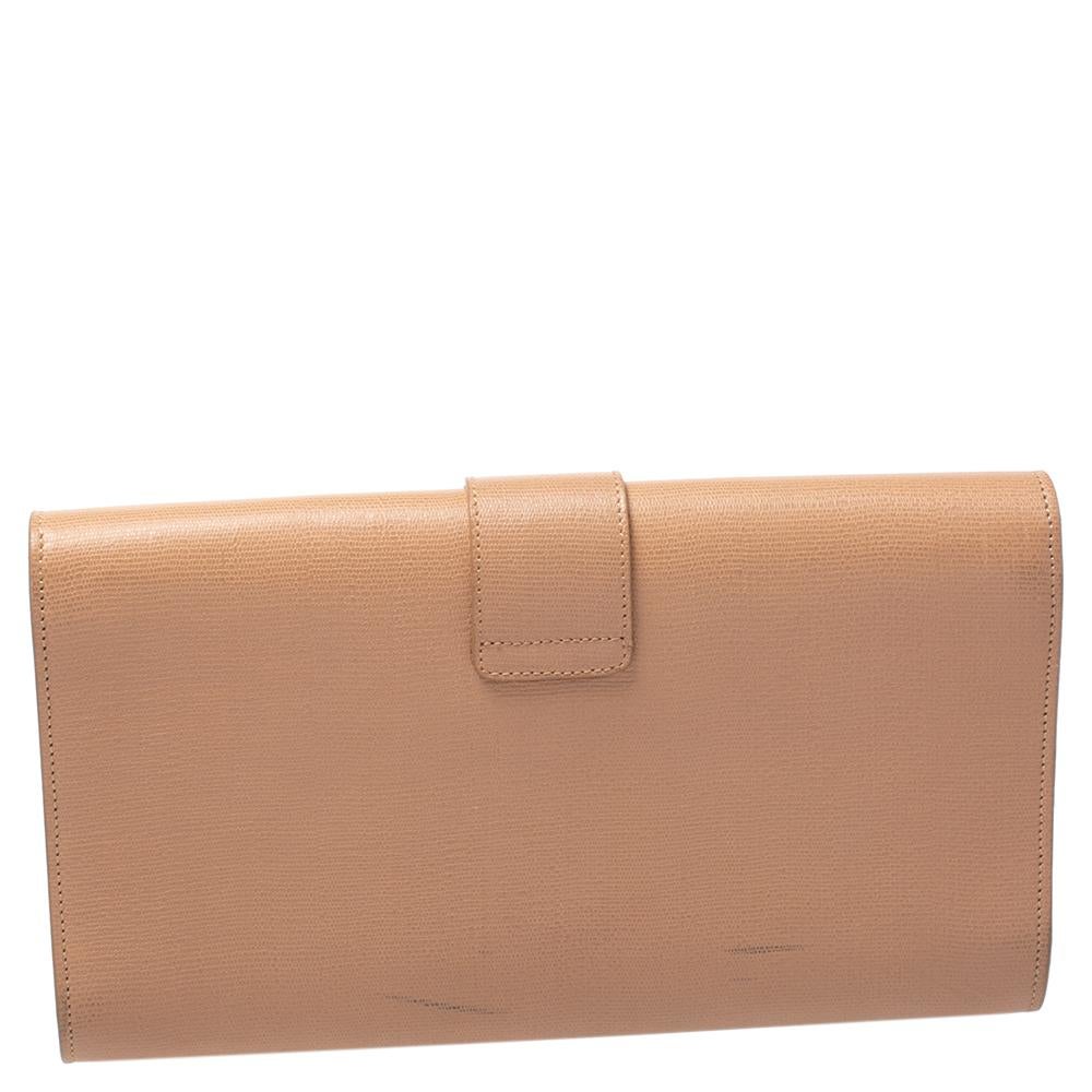 A simple design highlighted by a gold-tone Y on the front. The Y line clutch by Saint Laurent is crafted from beige leather and designed in a flap style. It has a spacious satin interior where you can carry your cards, cash and other