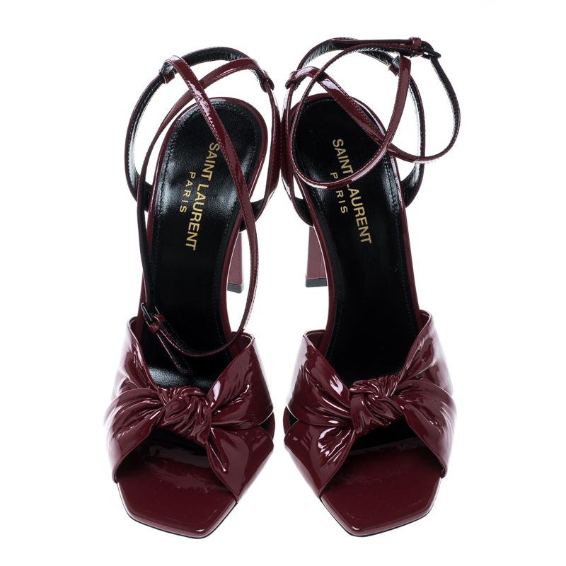 The pretty knot detailed frontal straps make this pair of Amy sandals from Saint Laurent Paris a pretty and elegant creation that looks just right for parties and other evening adventures. Rendered in red patent leather, these sandals have high