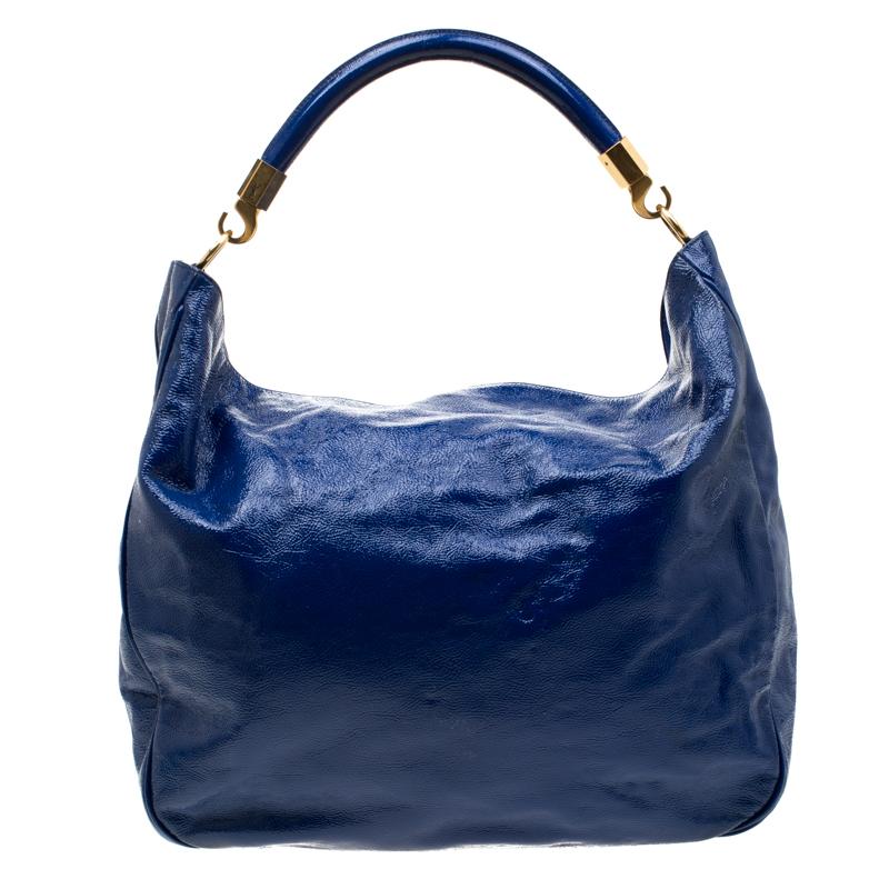This stunning Roady hobo handcrafted in Italy will make a standout addition to your collection. The gorgeous bag is made from royal blue patent leather and is accented with a single rolled top handle. With a beautiful play of gold-tone hardware, the
