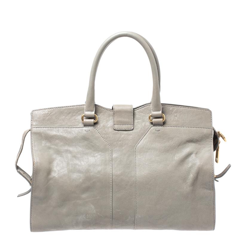 This elegant grey Cabas Chyc tote from Saint Laurent is ideal for everyday use. Crafted from leather, the bag is detailed with a gold-tone hardware Y motif snap closure at the front and dual-rolled handles. The top zip closure opens to a spacious