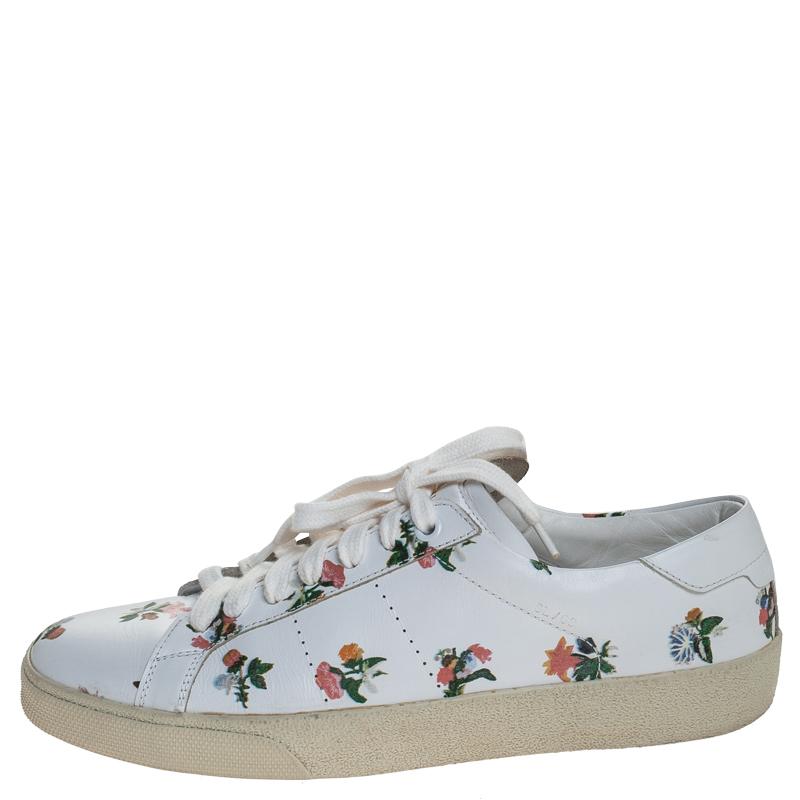 This pair of Saint Laurent Paris low top sneakers will make a mark for themselves in your closet. Crafted from leather, they feature a white floral print throughout. They come equipped with lace-up fronts, leather lining, and insoles as well as