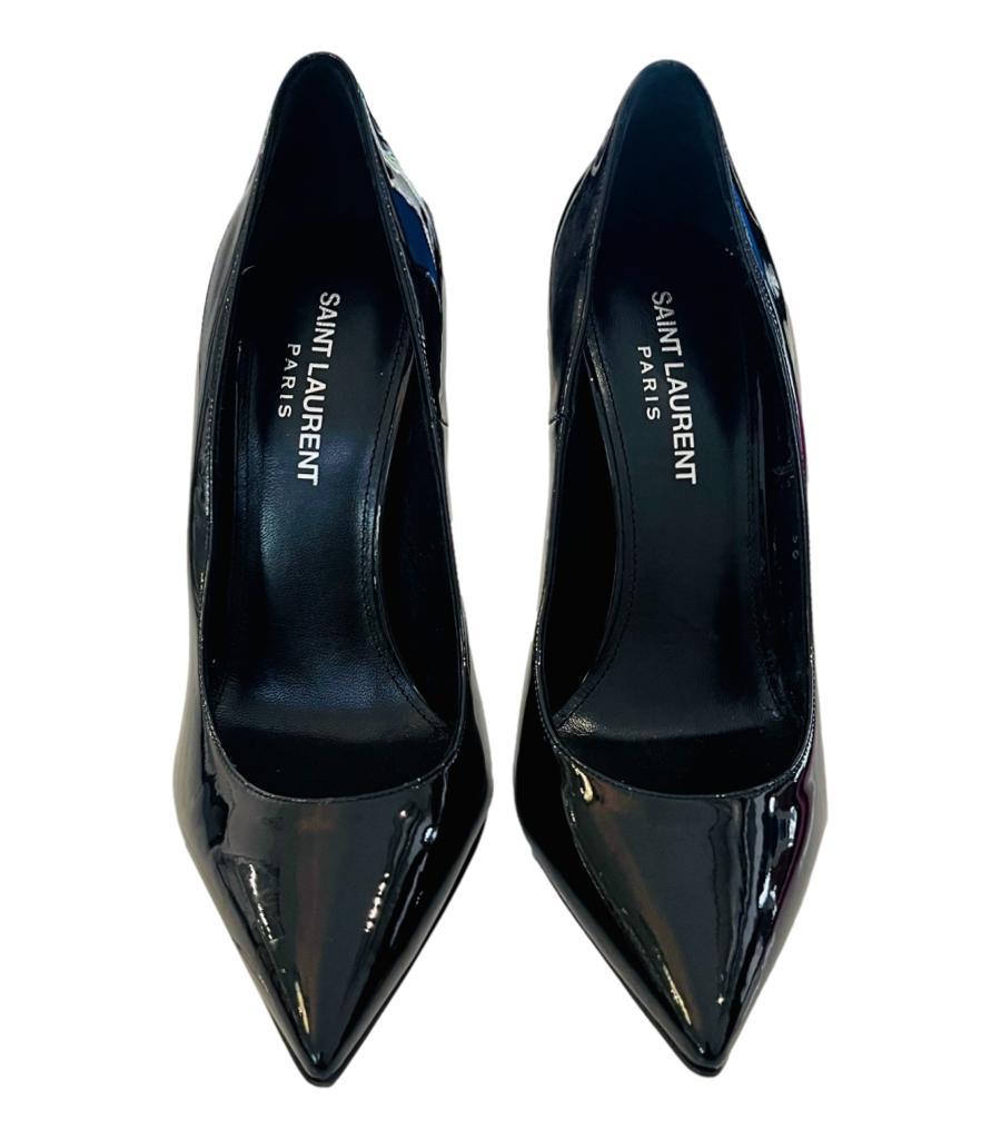 Saint Laurent Patent Leather Logo Opyum Heels
Black pumps crafted in glossy patent leather and detailed with silver 'YSL' heel.
Featuring pointed toe and leather lining.
Size – 36
Condition – Good (General signs of wear, scratched heels)
Composition