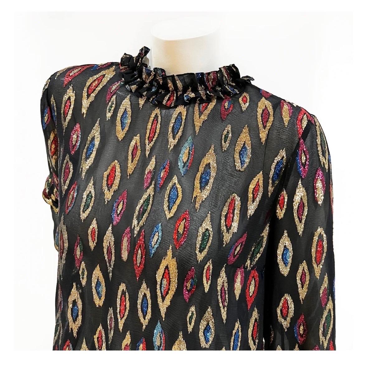 Peacock print blouse by Saint Laurent
Circa 2017
Made in Italty
Black with metallic gold/multicolor peacock feather print detail throughout
Long sleeve
Ruffle collar 
Gathered adjustable cuff ties
Button closure down the back of blouse 
Fabric